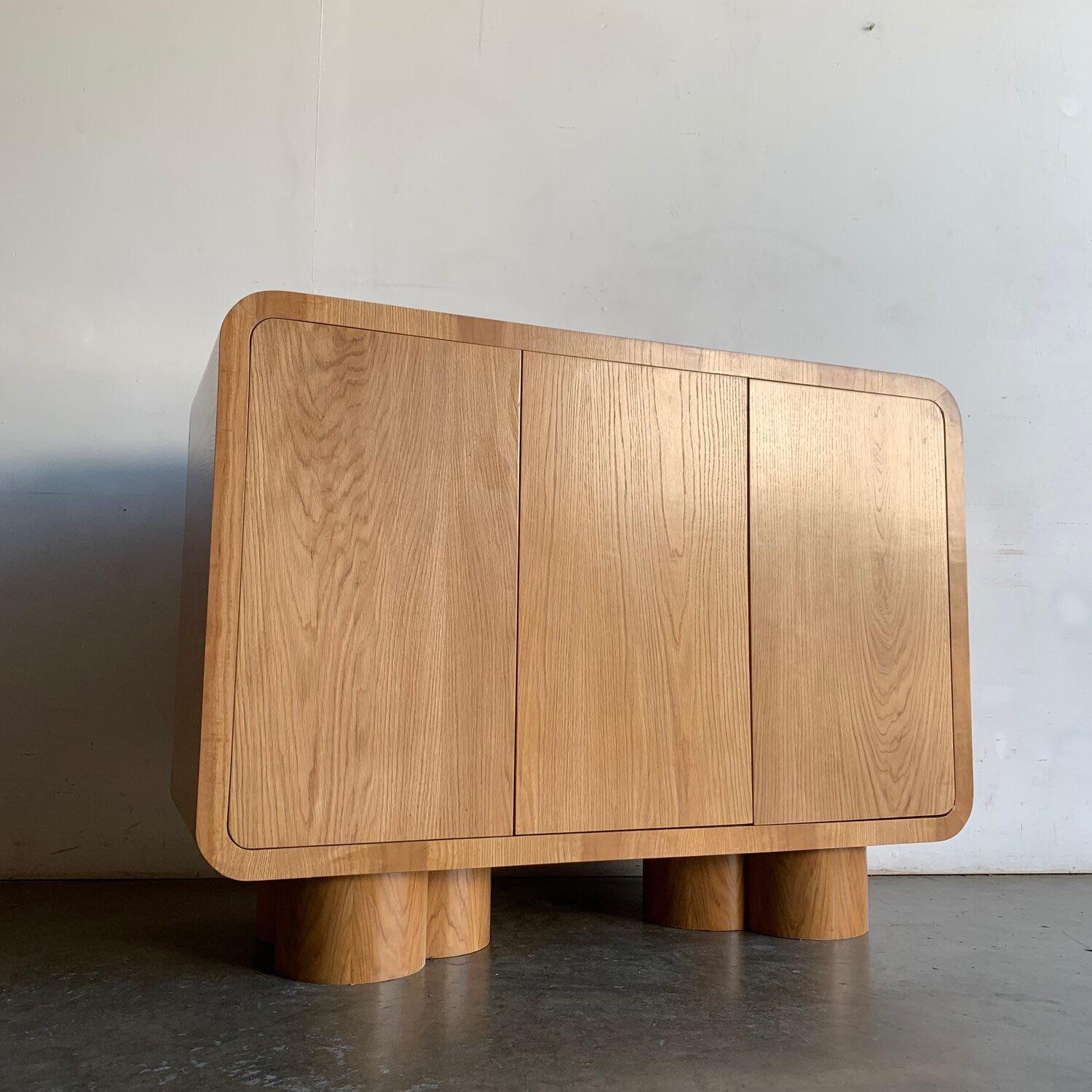 Made in house by Vintage On Point this large sideboard is made of solid and veneered white rift oak. This item features nice grain throughout, curved waterfall sides edges, sits on three merged cylinder legs, and has push open doors. 
These