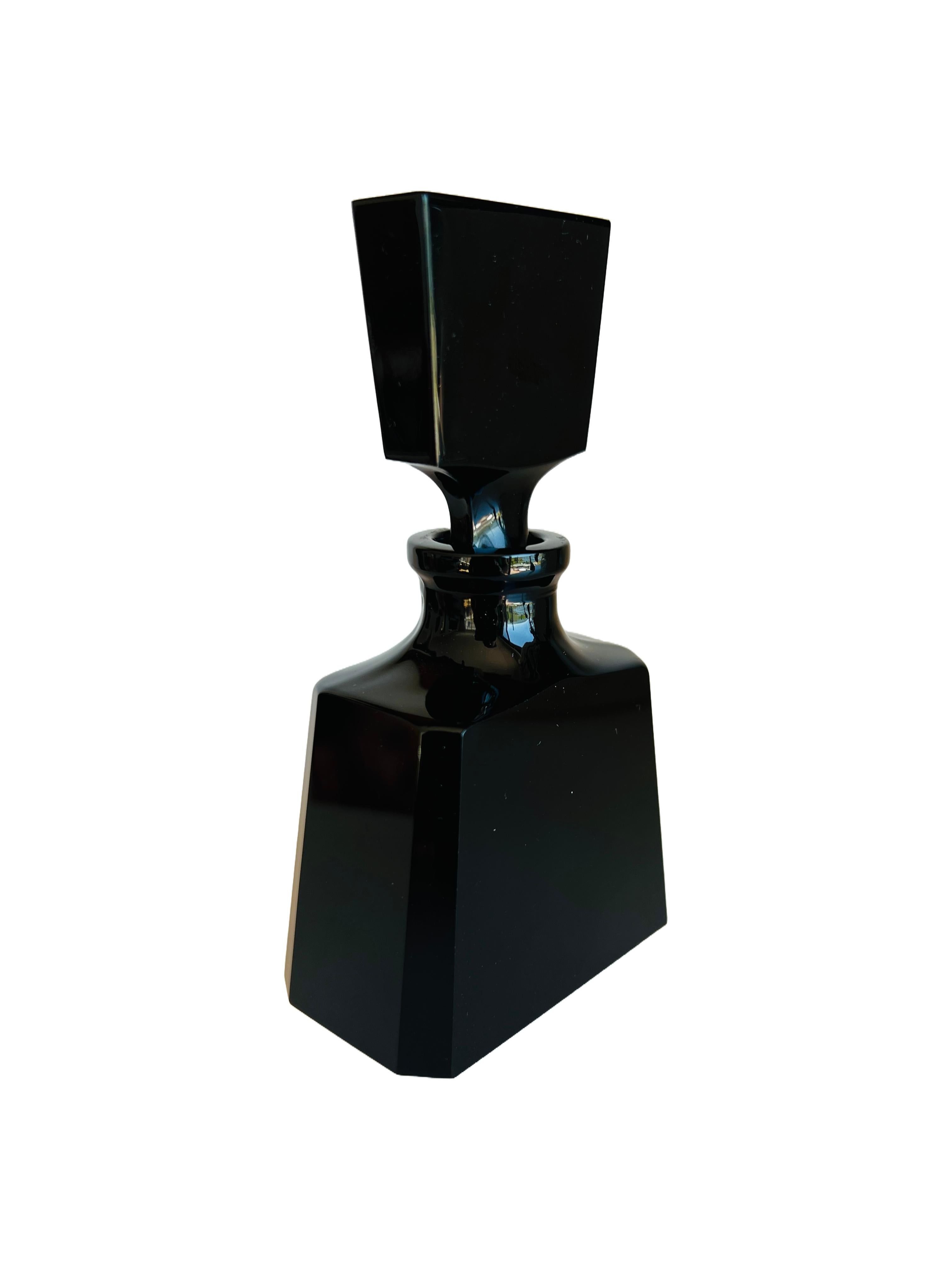 Cet élégant flacon de parfum en cristal de plomb Oneida, soufflé à la main, est un exemple frappant de l'élégance et de l'artisanat du milieu du 20e siècle. Fabriquée en cristal de plomb de haute qualité, la bouteille présente un élégant design Art