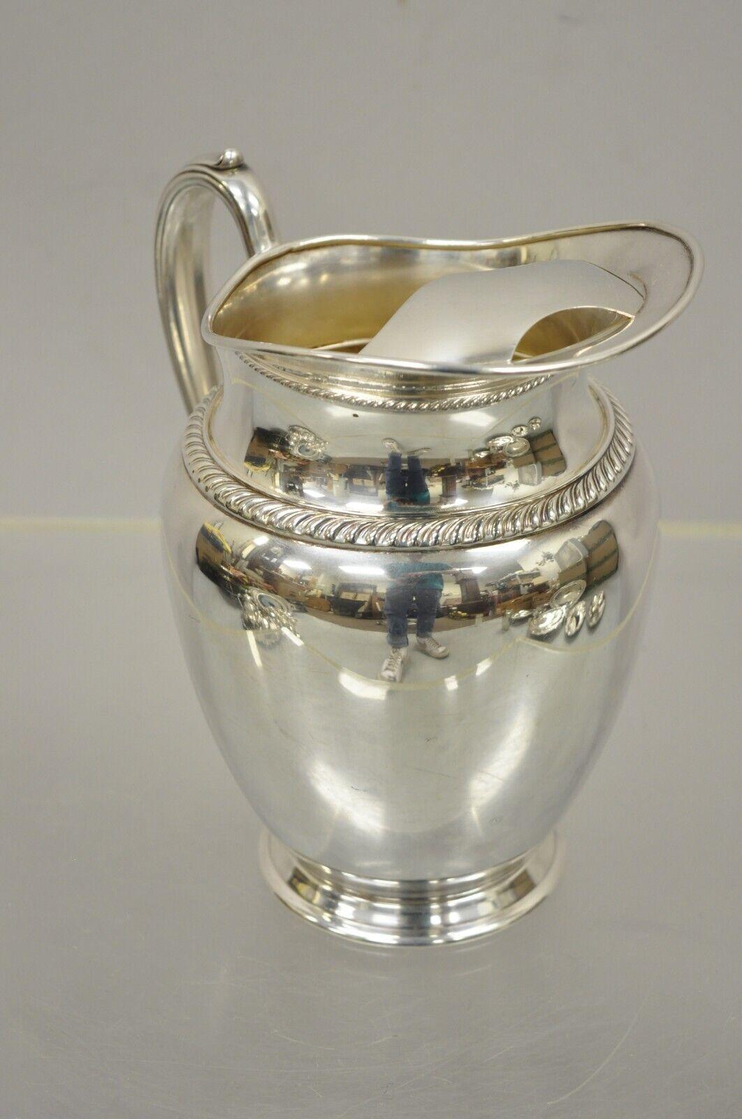 Vintage Oneida LTD Fiesta silver plate Regency Style Water Pitcher. Item features original stamp, very nice vintage item, quality craftsmanship, great style and form. Circa mid 20th century. Measurements: 8