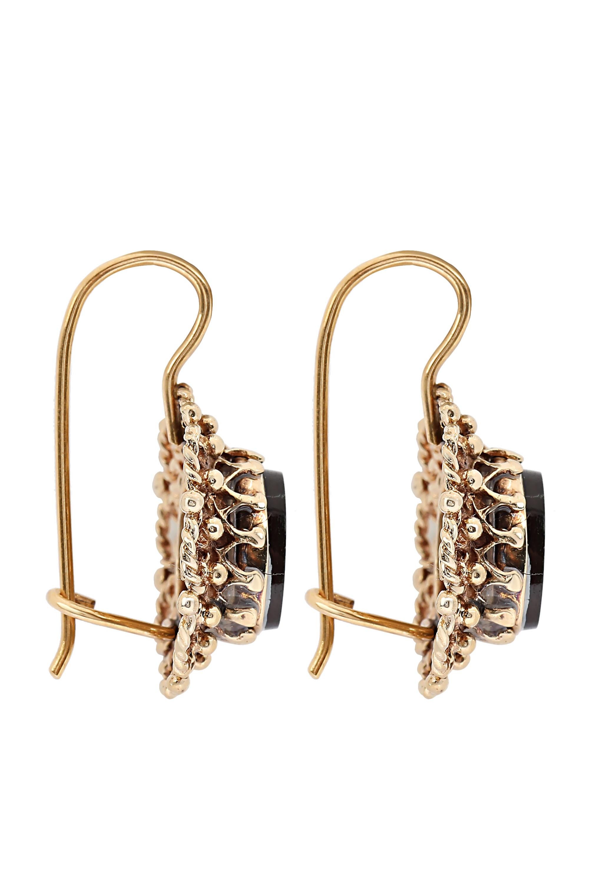 These attractive vintage drop earrings center onyx ovals in richly detailed 14 karat yellow gold frames completed by secure lever back findings. Earrings are 1” in total length and weigh 3.8 grams.