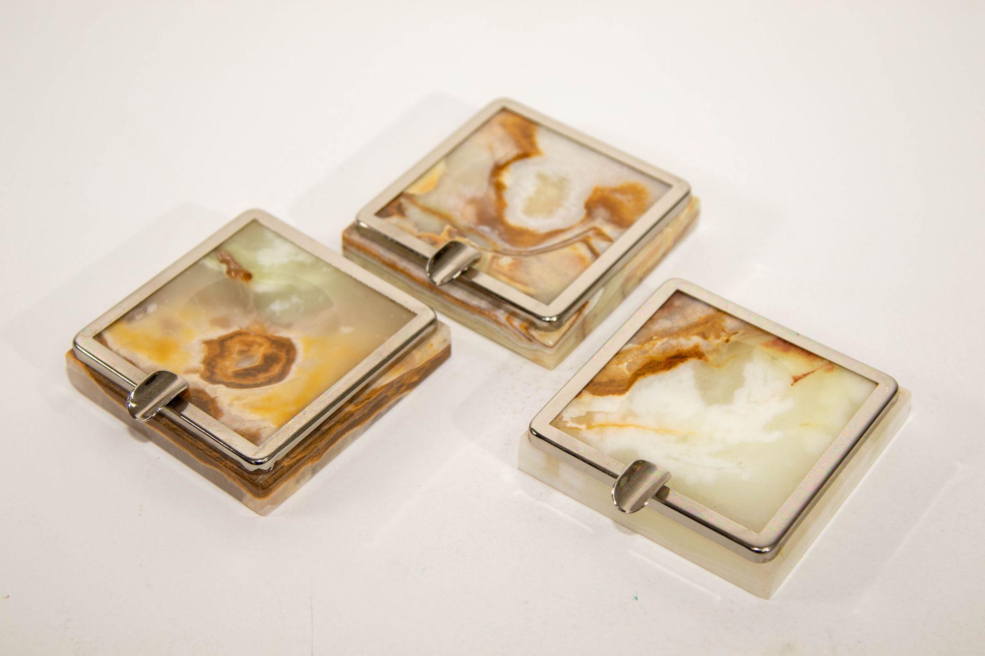 Onyx Art Deco Ashtrays Set of Three 1960 Made in Italy
Vintage set of three small onyx green ashtrays with silver white metal accent.
Elegant vintage ashtray made of precious white, brown and green onyx.
Mid-20th century stylish Art Deco green and
