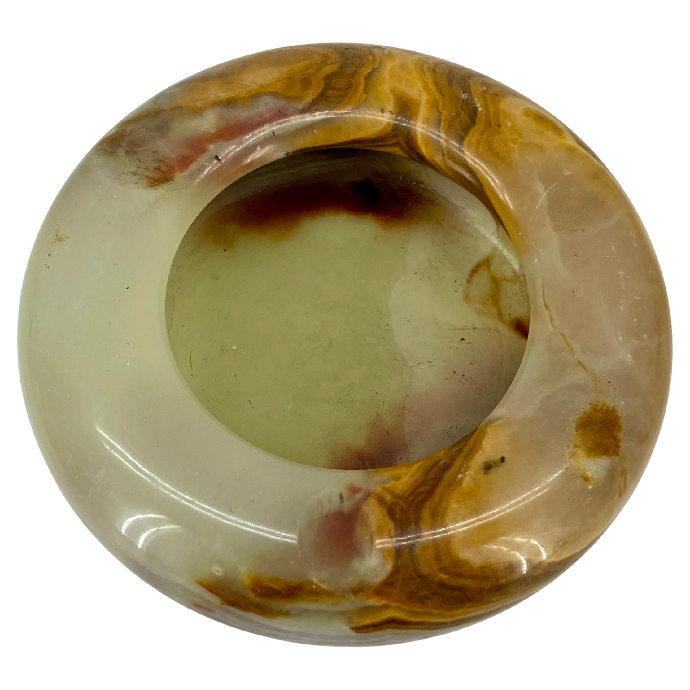 Mid-Century Modern round onyx bowl or ashtray. This outstanding onyx round bowl is made in Spain, 1950s. Carved and polished onyx stone, showing the mineral’s distinctive banding striations. Beautiful to be used as vide-poche, decorative bowl or