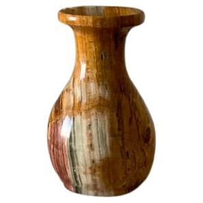 Solid onyx vase. Lovely veining and color detail from oranges, greens to deep reds and browns.