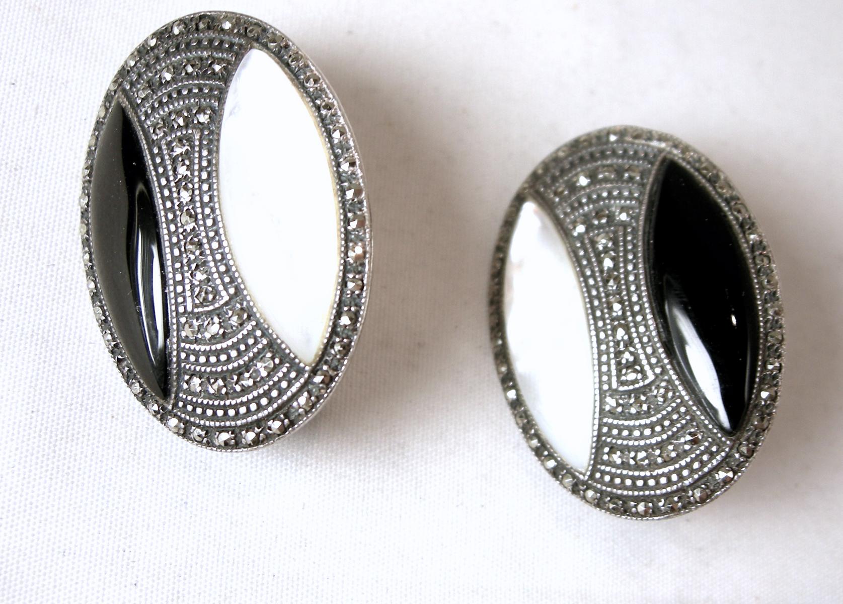 These vintage earrings feature onyx, marcasites and mother of pearl in a sterling silver setting.  In excellent condition, these clip earrings measure 1-1/4” x 7/8”.