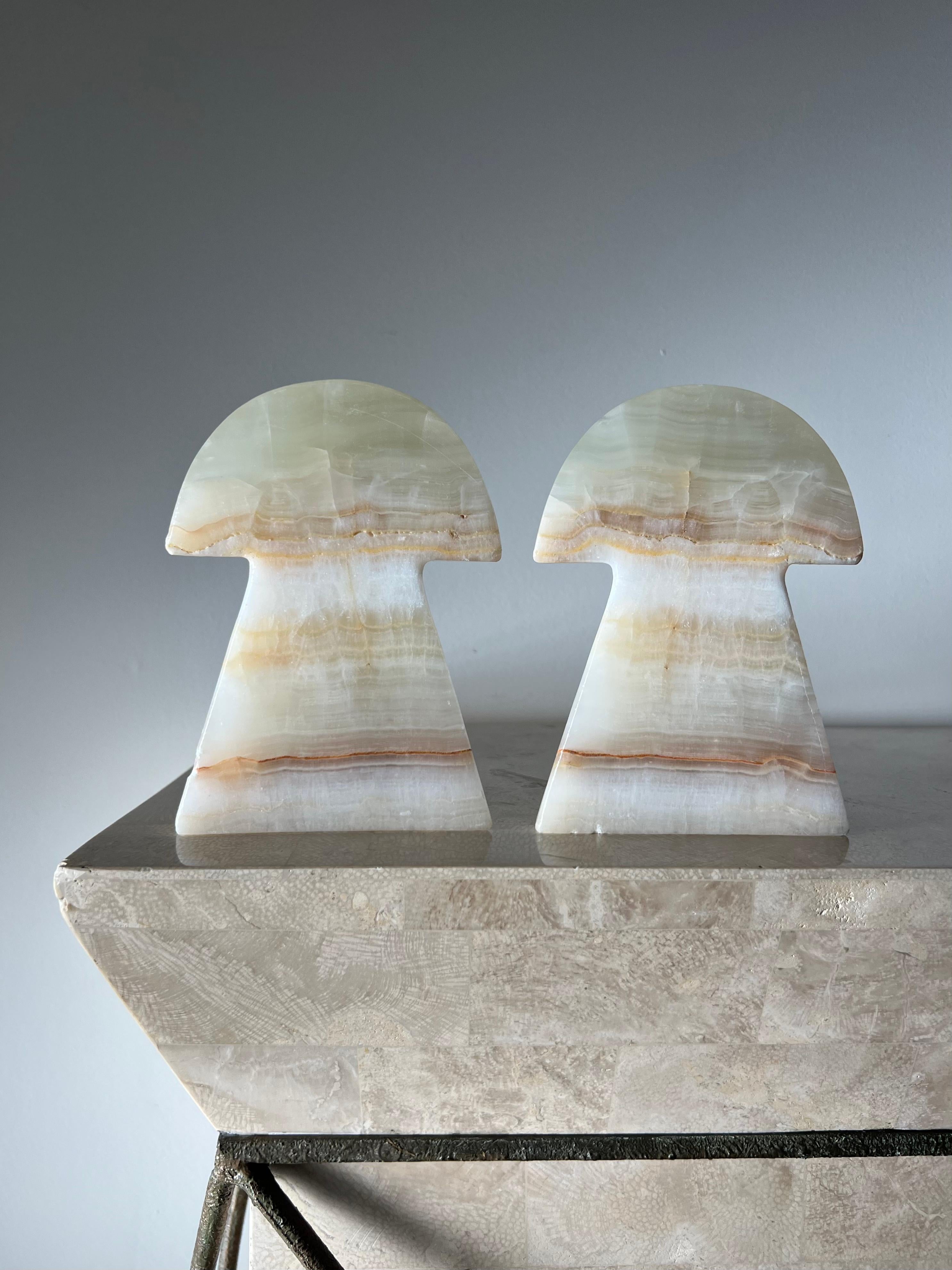 A pair of vintage Italian onyx mushroom bookends, 1960s. Tones of cellophane, caramel, and rust. Minor signs of wear consistent with age but no outward flaws. 
as a unit: 4.5” W x 4.5” D x 6.5” H.