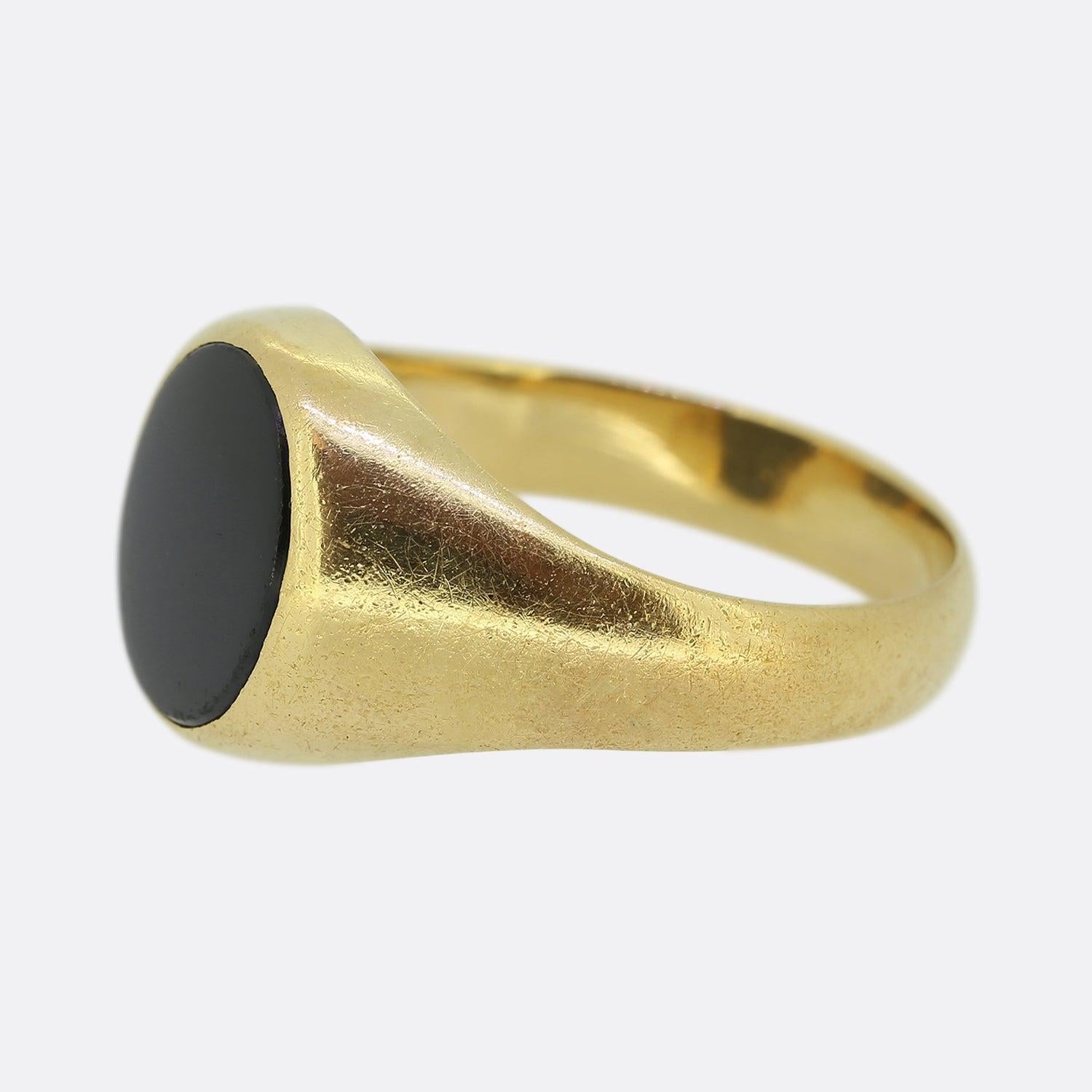 Here we have a vintage signet ring crafted from 18ct yellow gold. This classic piece showcases an oval shaped face which plays host to a matching onyx at the centre amidst a pair of plain wide shoulders. 

Condition: Used (Very Good)
Weight: 8.0