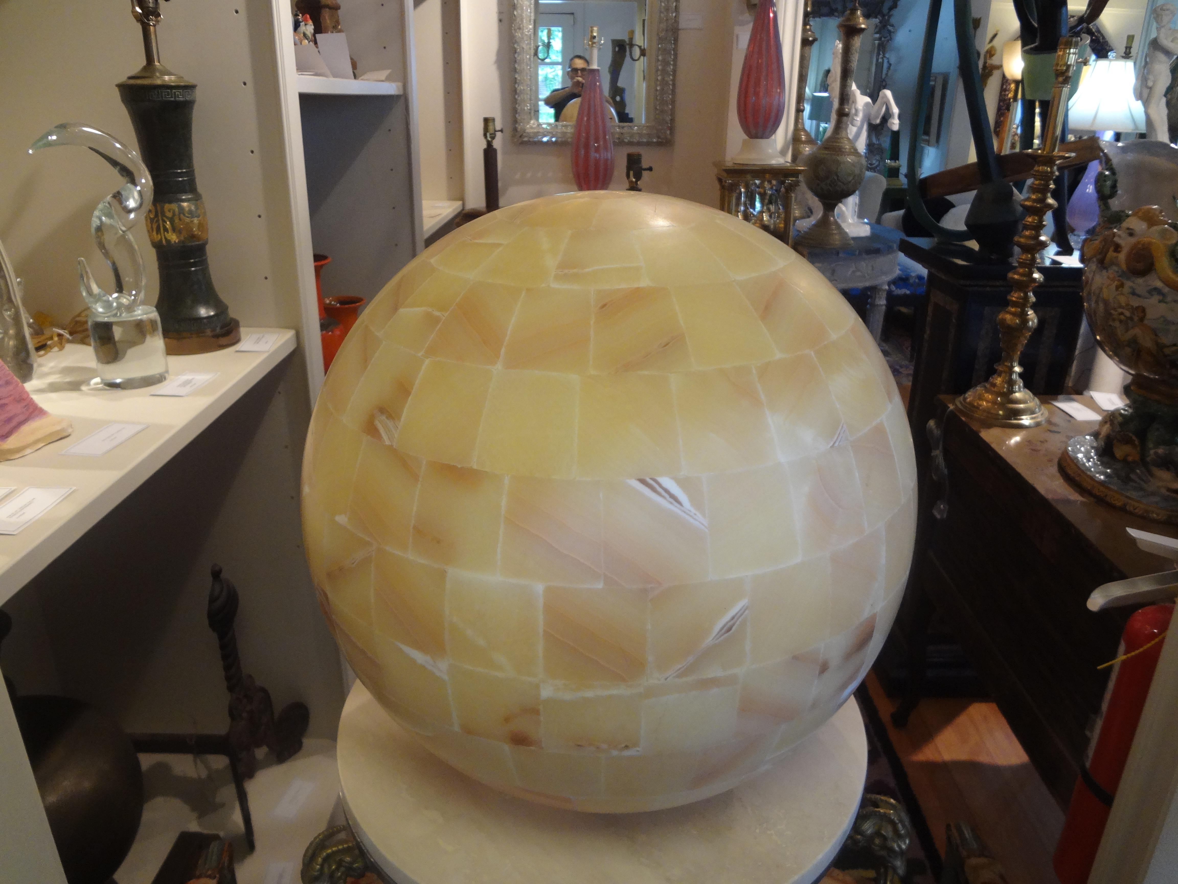 Large vintage onyx sphere lamp. This stunning 20th century onyx table lamp is comprised of cut and polished onyx in a circular sphere that emits a beautiful effect when lit.