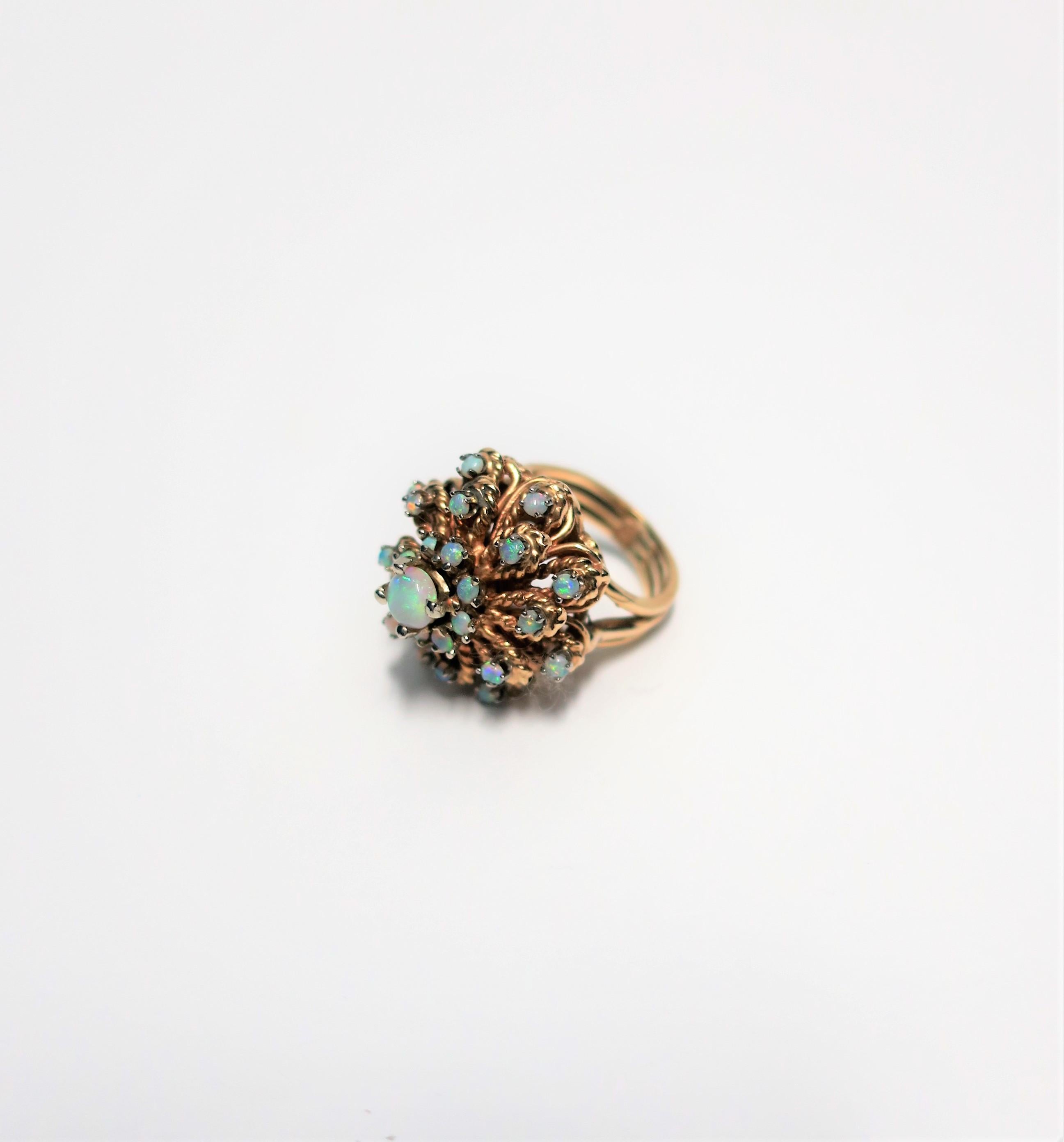 A very beautiful vintage opal and 14-Karat yellow gold cocktail ring, circa 1960s. A substantial and large cocktail ring comprised of 22 opals, all prong set, with a ribbed shank. A rare find. Ring is a size 6.25. Size of ring can be adjusted by a