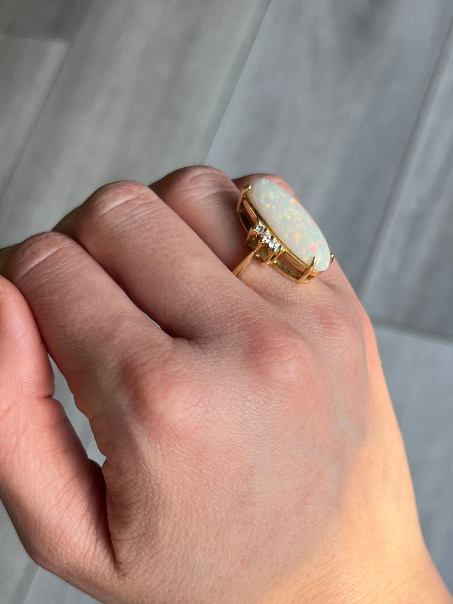The opal is pale in colour and has lots of flashes of red and all other colours within it. The diamonds either side of the opal total 15pts each side. The ring itself is modelled in 18ct gold. London 1972.

Ring Size: K 1/2 or 5 1/2 
Height off