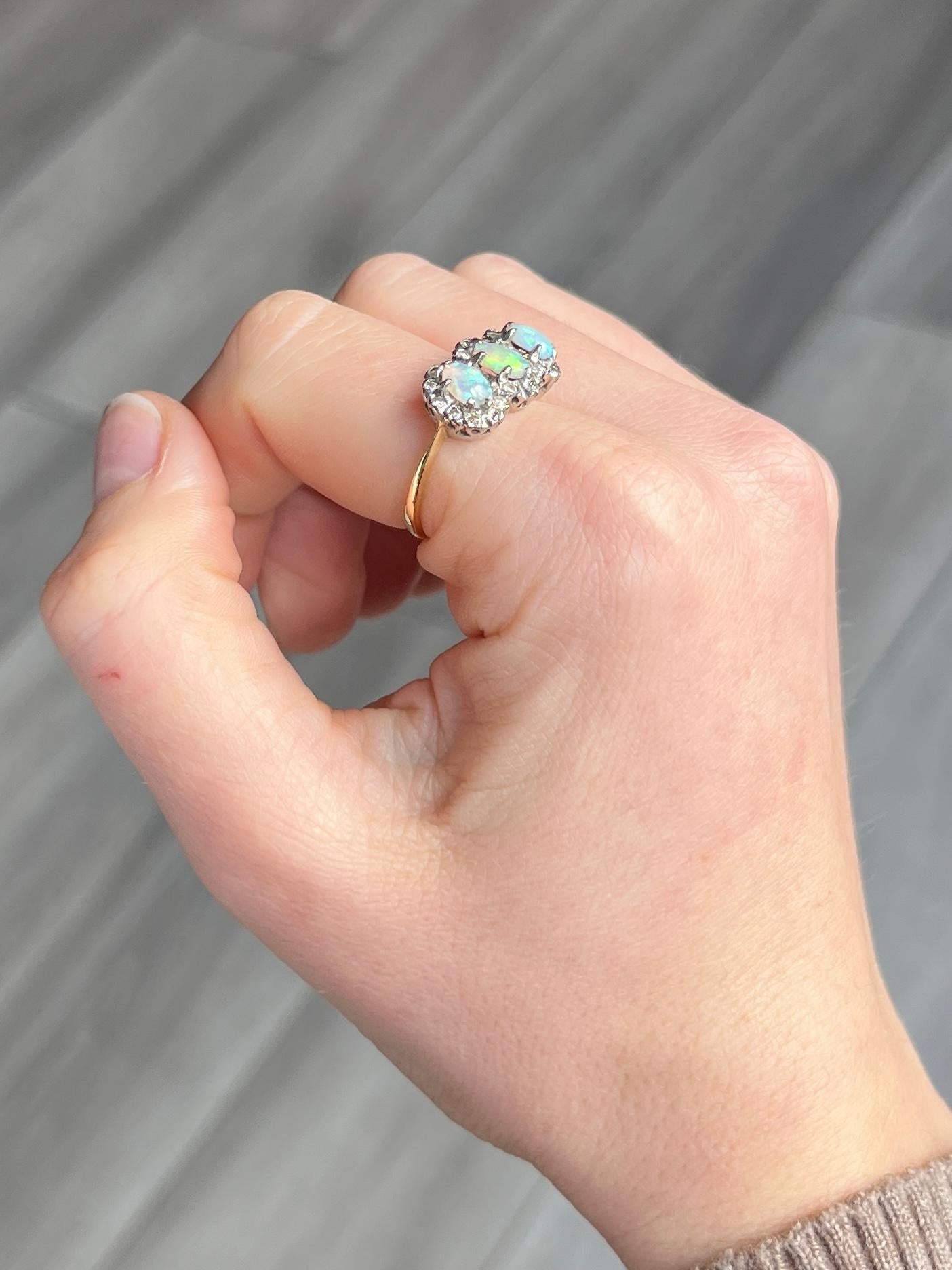 This stunning triple cluster holds three colourful opals and these are surrounded by diamonds. The diamond total is approx 52pts. Each opal measures 35pts. Modelled in 18carat gold and stones set in platinum. Fully hallmarked London 1977.

Ring