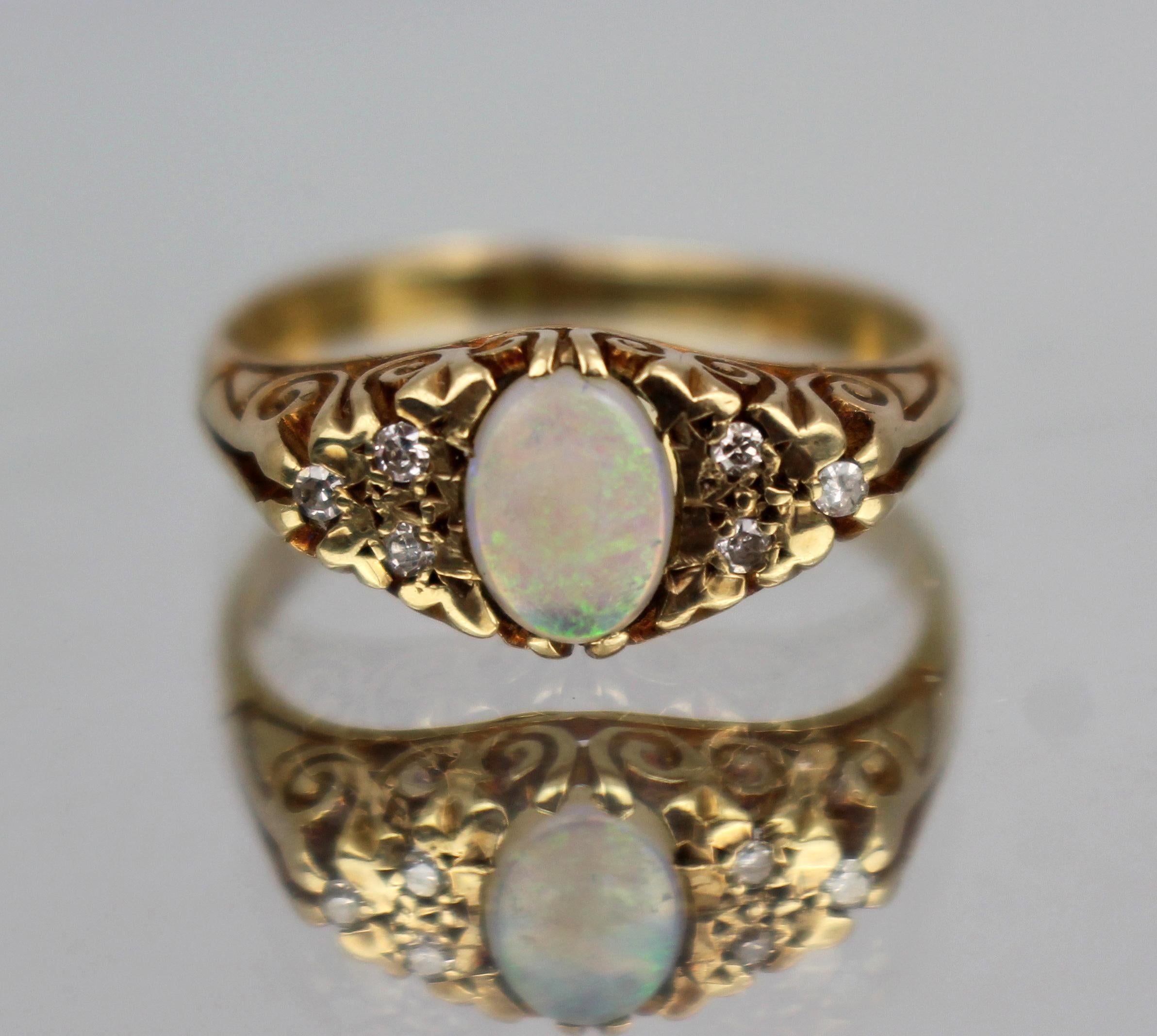 Anello d'epoca con opale e diamanti in oro 9 carati, inglese, 20° secolo

Un anello vintage splendidamente realizzato con un'opale ovale luminosa, accentata da sei piccoli diamanti in una montatura a spirale di ispirazione floreale. L'opale mostra
