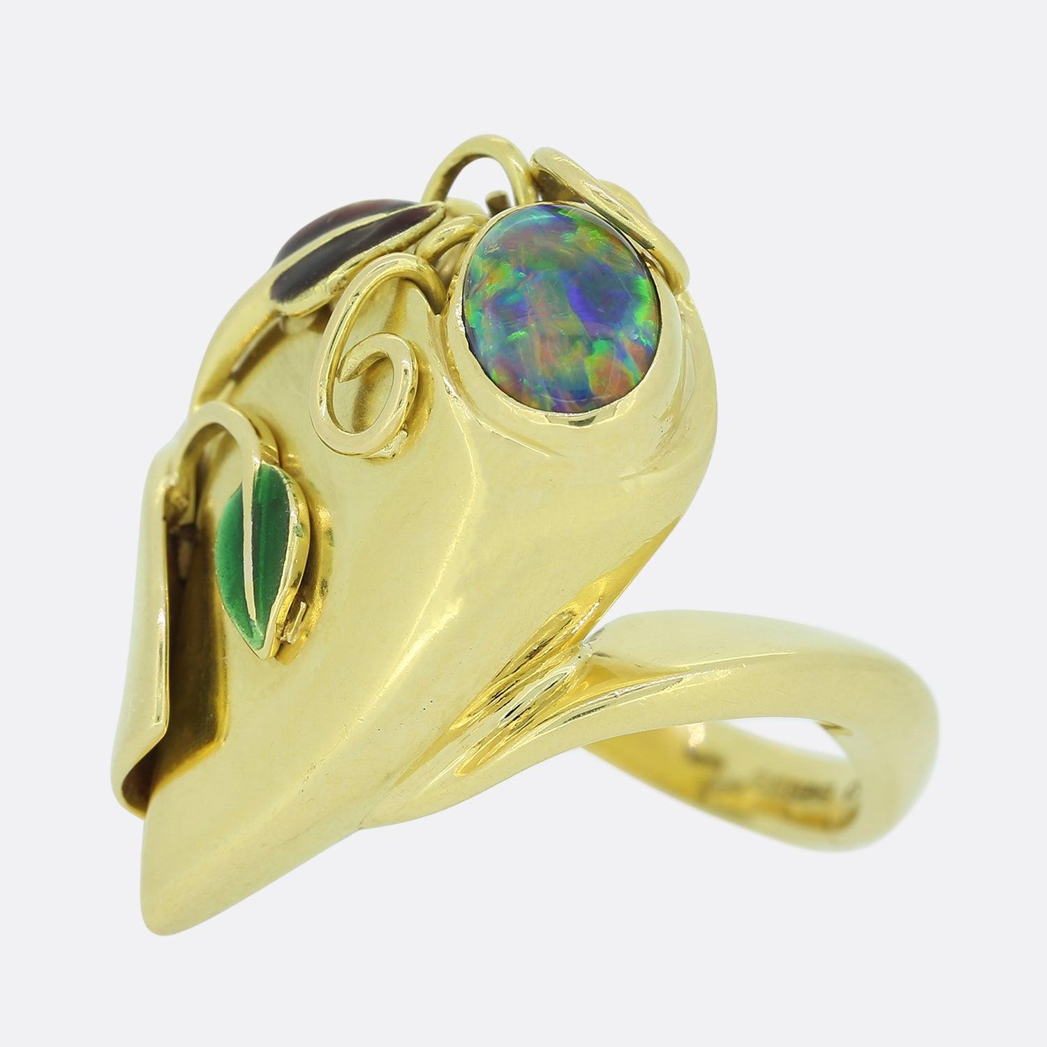 Dieser Vintage-Ring beherbergt einen ovalen schwarzen Opal, der von grüner und violetter Emaille in einem floralen Muster umgeben ist. Der Ring ist aus 18 Karat Gelbgold gefertigt. Der Opal hat ein wunderbares Farbspiel und ist ein sehr begehrter