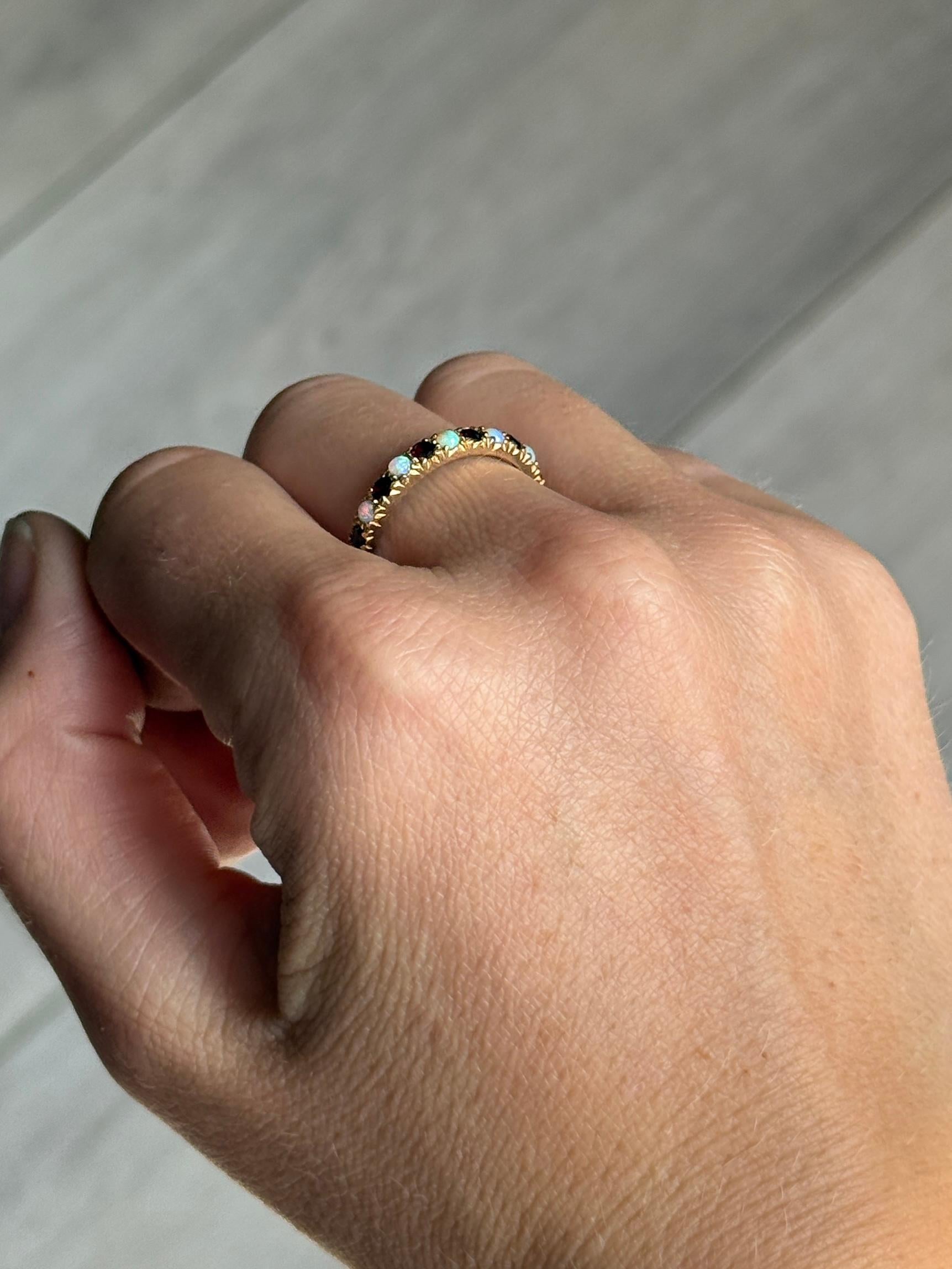 The opals in this ring are gorgeous and throw some great colours. In between each opal is a deep red garnet. They are set flush within the 9ct gold claws. 

Ring Size: O or 7 1/4 
Face Width: 2.5mm 
Height Off Finger: 2mm

Weight: 2.1g