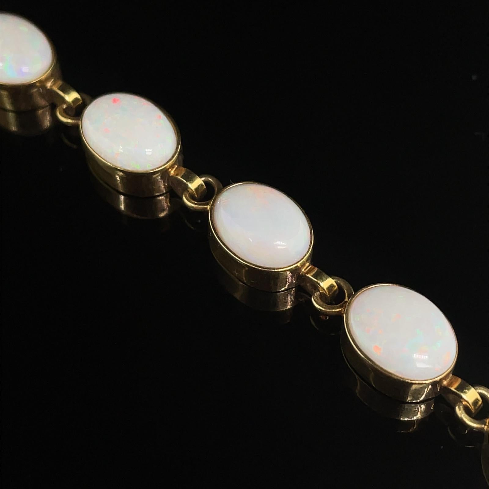 A vintage opal bracelet in 9 karat yellow gold, circa 1990.

This pretty bracelet comprises of oval cabochon white opals in elegant rubover settings joined with plain polished cable links, finished with a box clasp fitting and safety chain for added