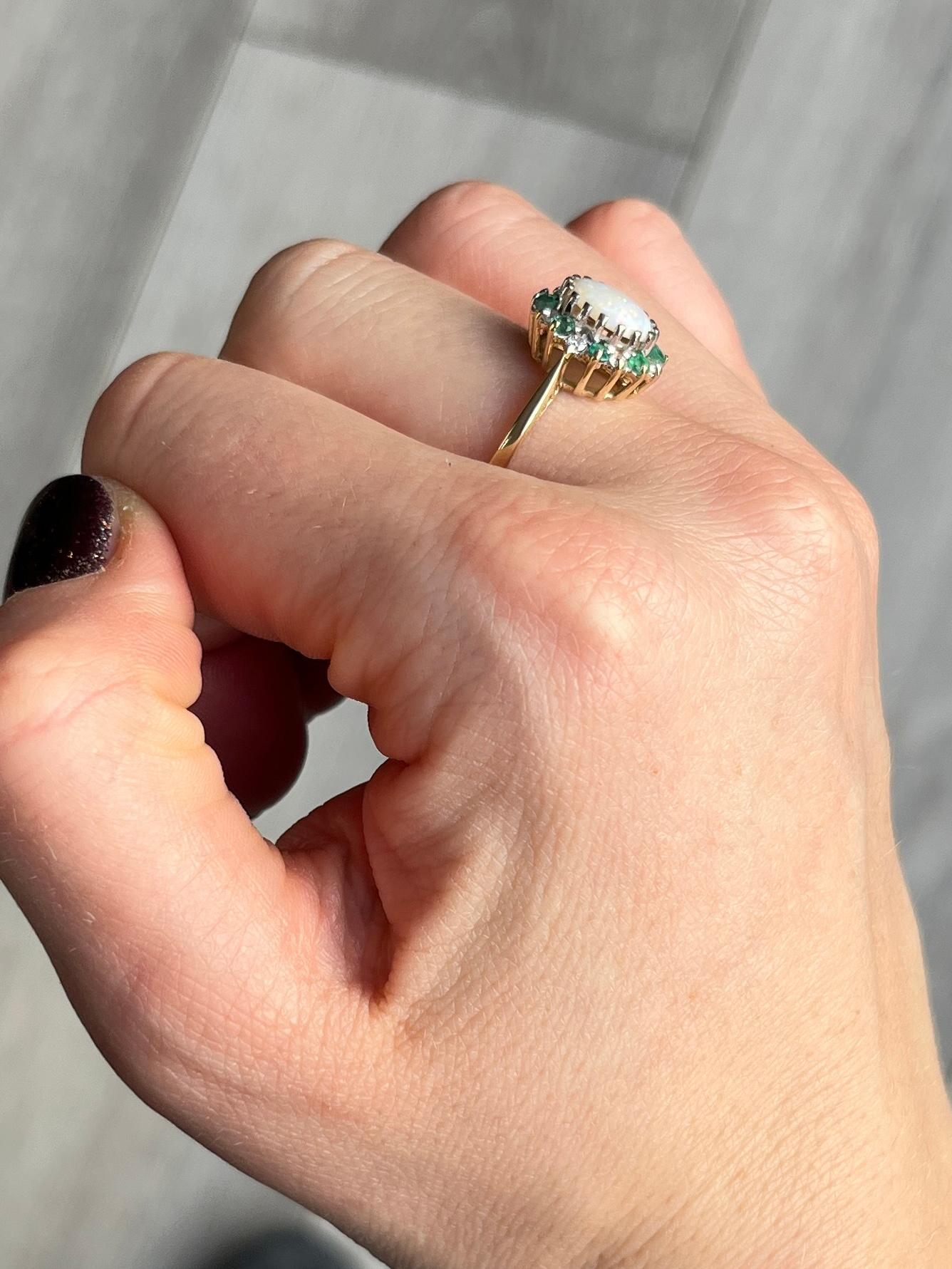 Dieser prächtige Opal wird von einem Halo aus abwechselnden Diamanten und Smaragden umgeben. Der Diamant hat insgesamt 24 Punkte und der Smaragd insgesamt 24 Punkte. Der Opal ist glatt glänzend mit vielen Farbflecken und misst ca. 1 Karat.