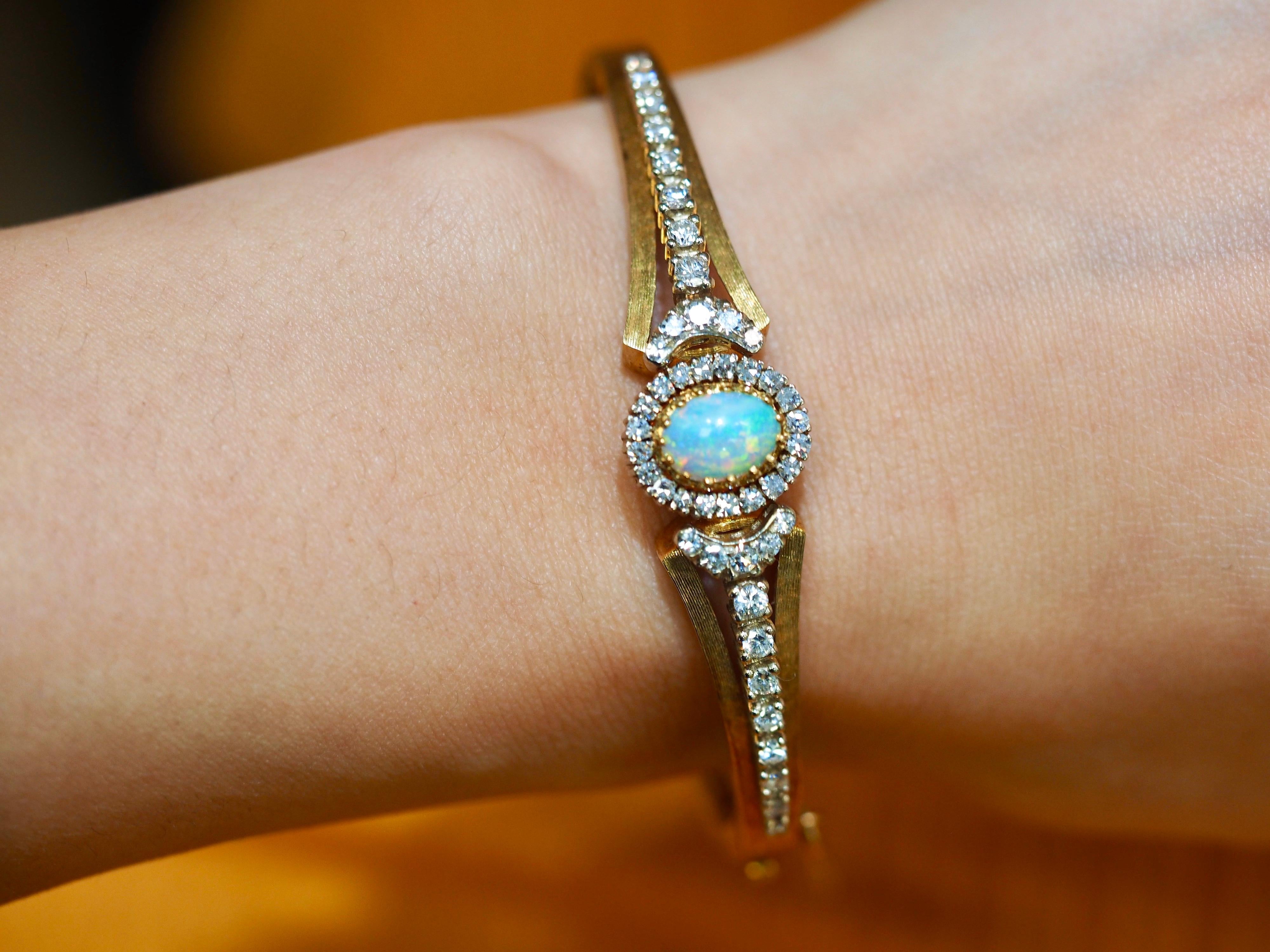 Place Vendôme Vintage diamond opal bracelet is absolutely striking dating back to the 1940's. The center is a multi-colored Ethiopian Opal ranging in colors of blues, greens, purples with reflection fiery red from different angles. Accenting this