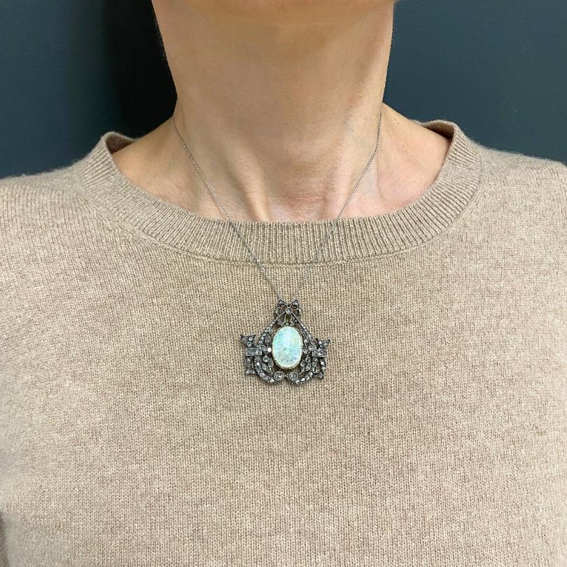 Un delicato ciondolo opale vintage con diamanti taglio rosa e realizzato in oro e argento 10k sospeso a una catena in oro bianco 18k.u2028Questo ciondolo opale vintage presenta una combinazione di morbida luminosità e dettagli scuri. Un opale ovale