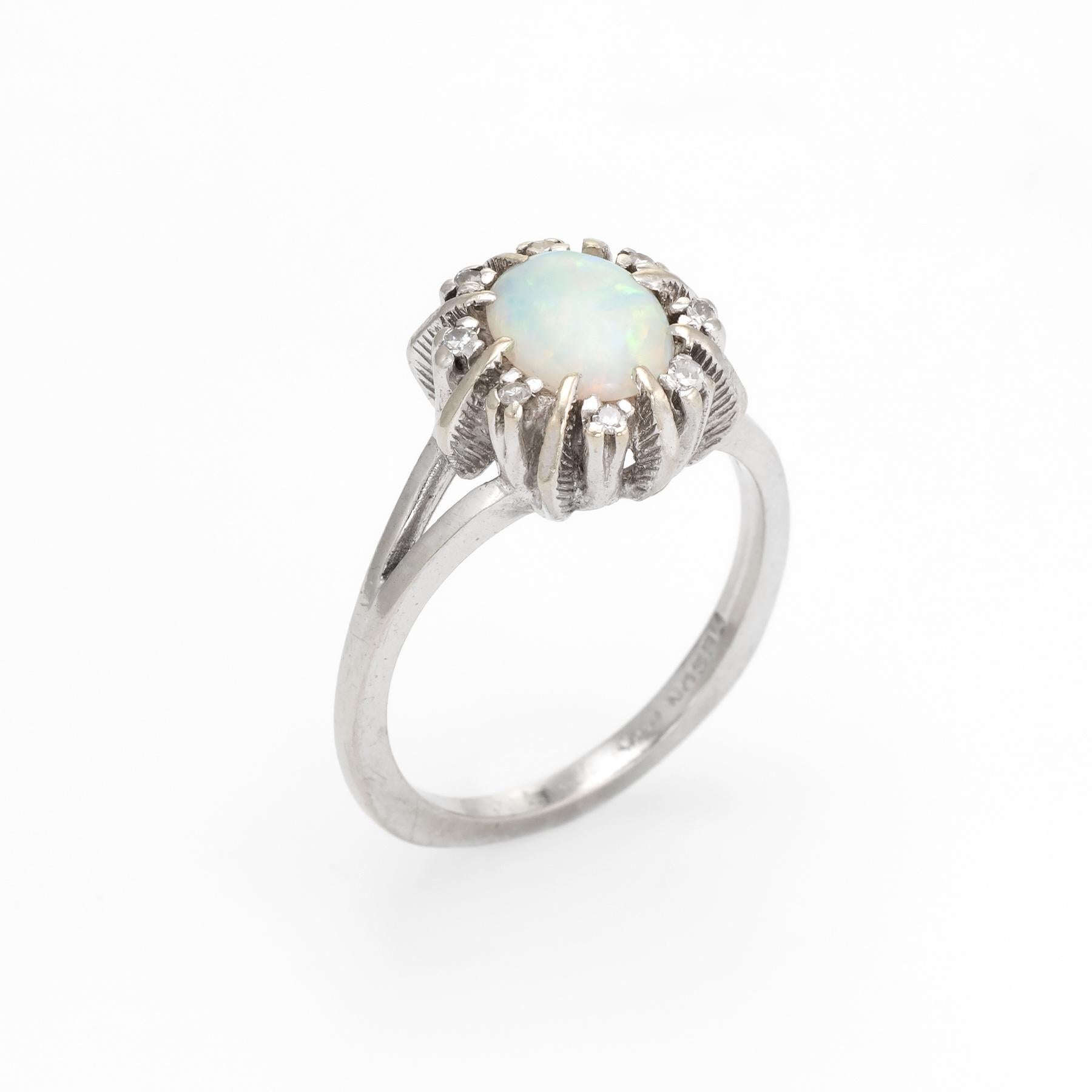 Finely detailed vintage opal & diamond cocktail ring (circa 1950s to 1960s), crafted in 14 karat white gold. 

Centrally mounted natural opal measures 7.5mm x 5.5mm (estimated at 1 carat), accented with eight estimated 0.01 carat single cut diamonds