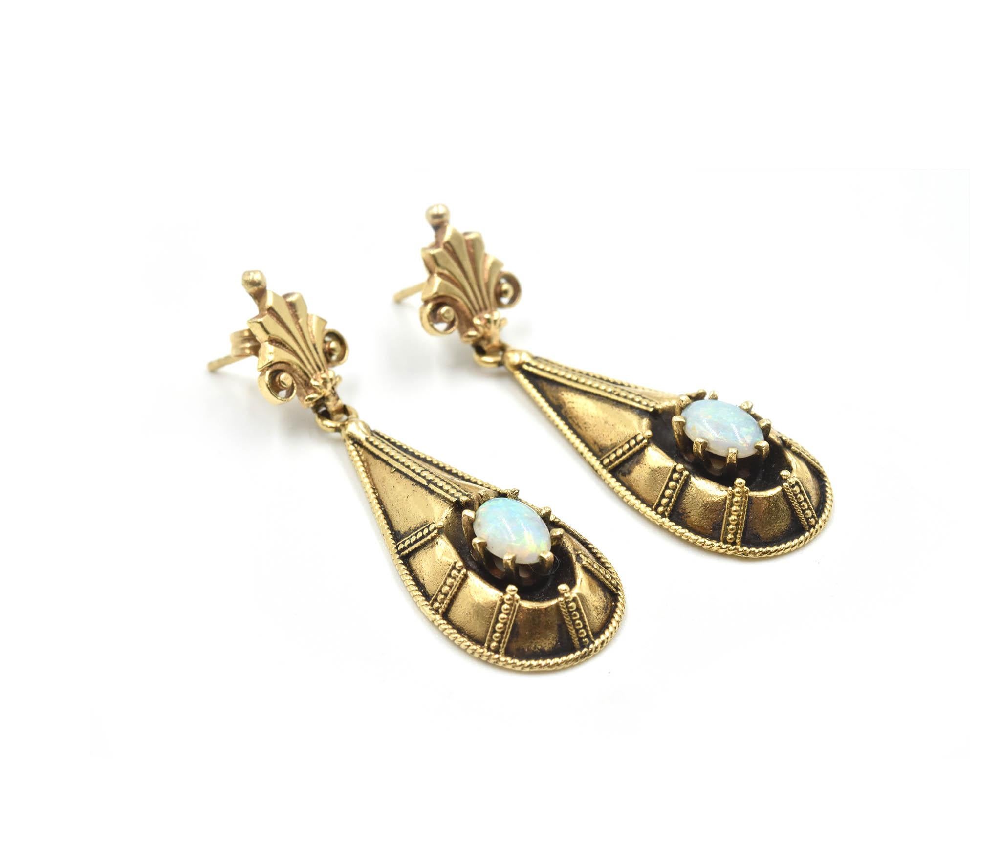 Designer: custom design
Material: 14k yellow gold
Opal: two oval shape cabochon gemstones
Fastenings: friction back fastenings
Dimensions: each earring measures 1 3/4-inches long and 1/2-inches wide  
Weight: 9.93 grams
