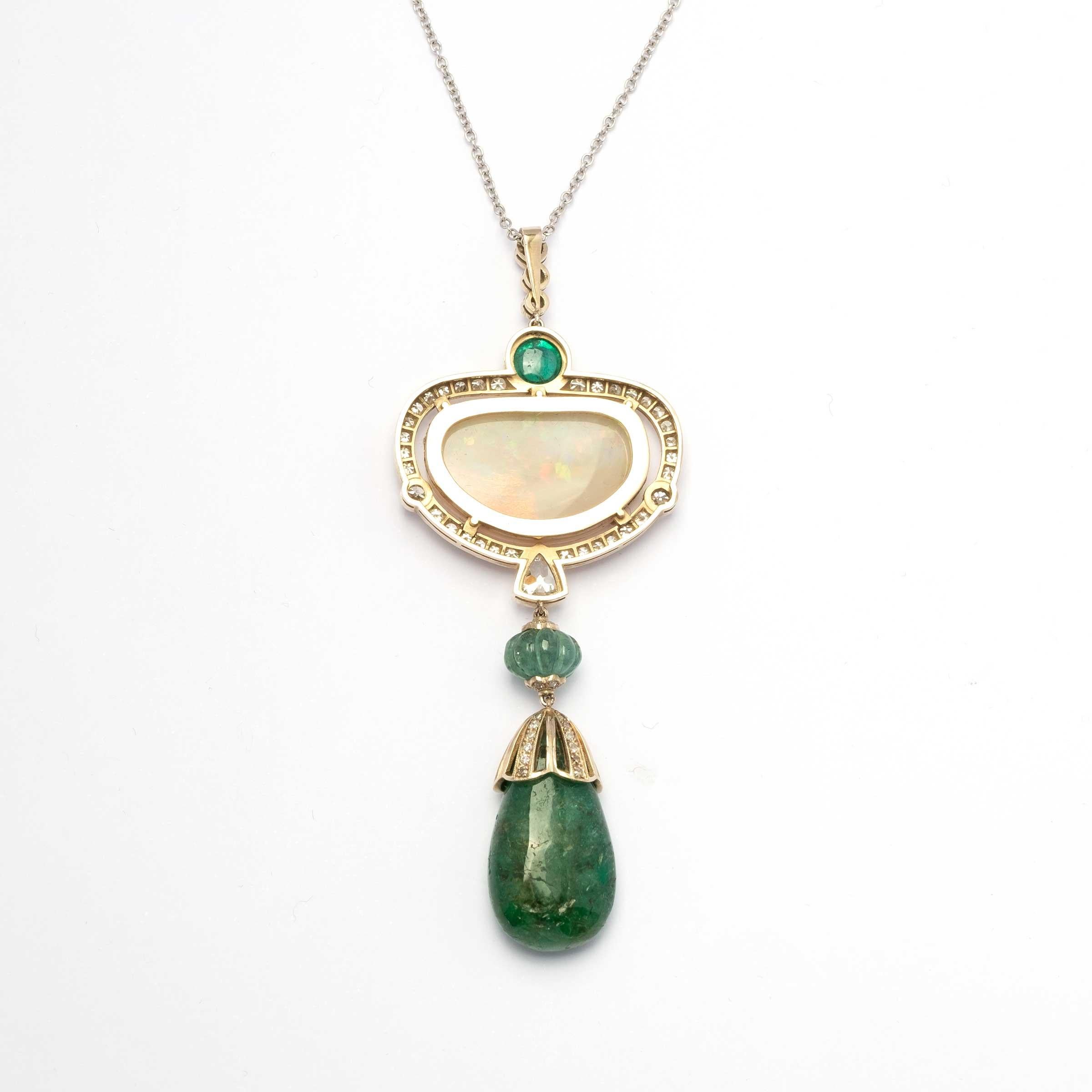 Vintage pendantif set in white and yellow 18ct gold,
centering an important white harlequin opal, highlighted by emeralds in various shapes (cabochon, engraved and drop) for 7ct total c.a. and diamonds for 1.40 ct total c.a.

Highlights:
- 18ct gold