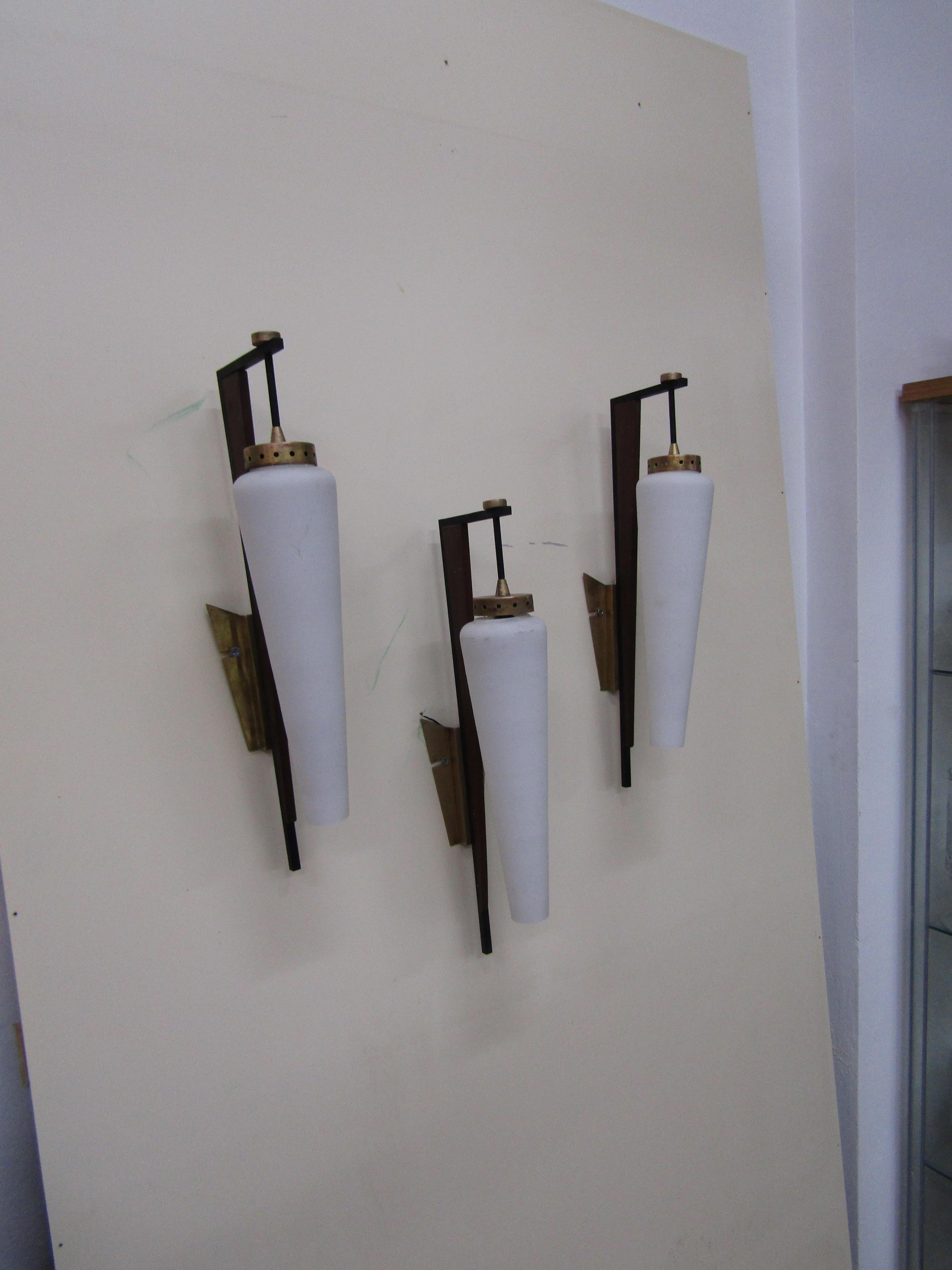 - 3 wall lights produced by Stilnovo
- Made of opal white glass
- Frame in bronze, metal and wood veneer
- Requires an E14 bulb.