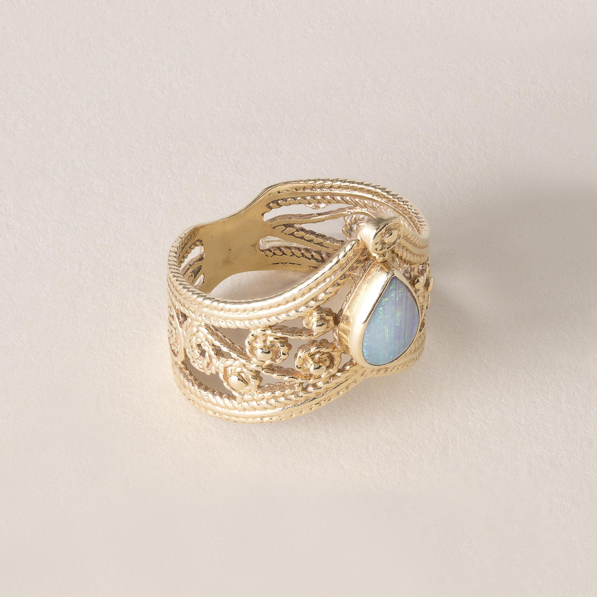 Circa anni '70
Un'opale a forma di pera con castone in oro 14k
Lampi blu e verdi
Tiara dal design ornato, grani di mulino e dettagli in filigrana
4.1 grammi
Anello misura 6,25
Mancano 2 foto