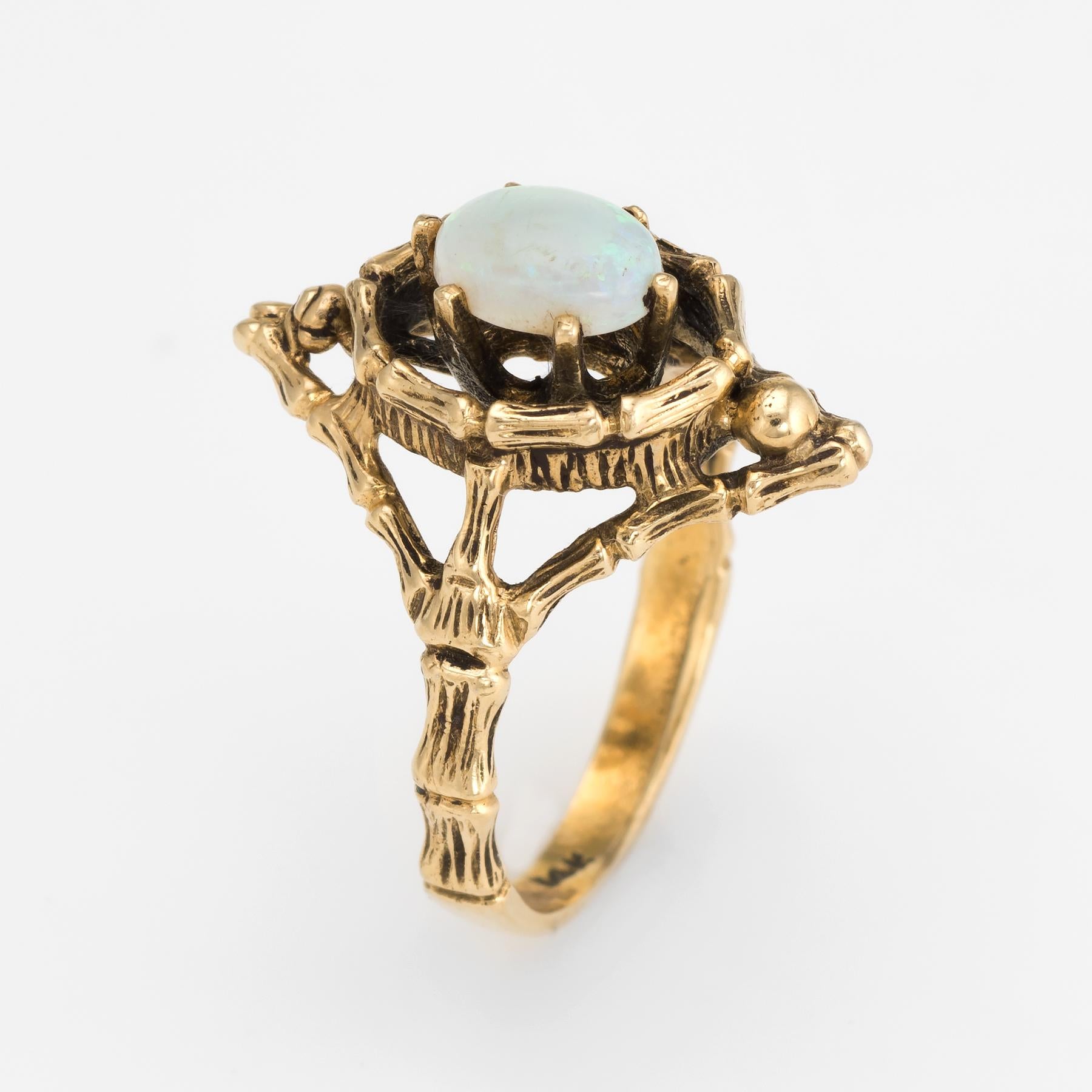 Finely detailed vintage opal cocktail ring (circa 1960s to 1970s), crafted in 14 karat yellow gold. 

Cabochon cut opal measures 7mm x 5mm (estimated at 0.60 carats). The opal is in excellent condition and free of cracks or chips. 

The stylish ring