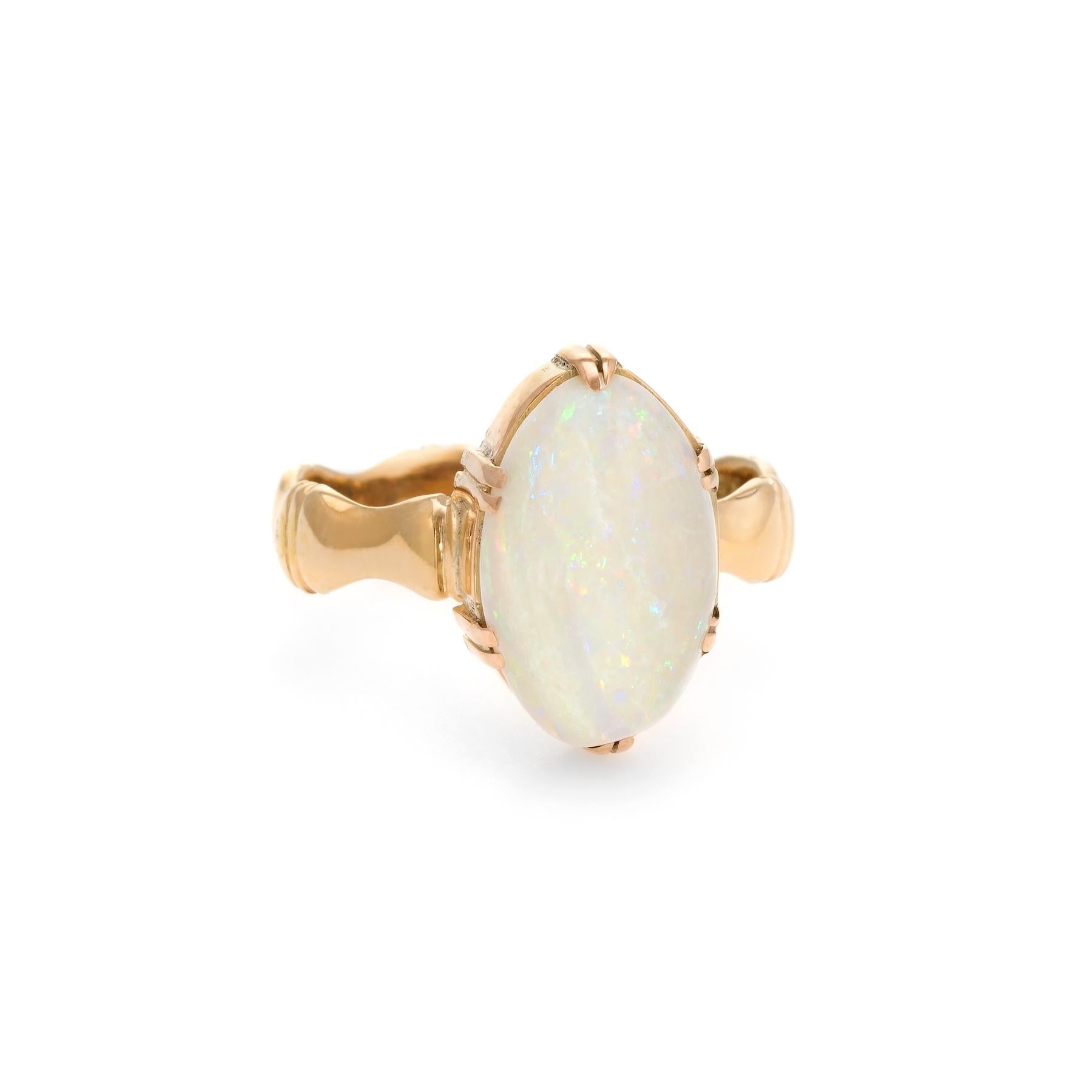 Finely detailed vintage opal cocktail ring (circa 1960s to 1970s), crafted in 14 karat yellow gold. 

Cabochon cut natural oval opal measures 15mm x 10mm (estimated at 7 carats). The opal is in excellent condition and free of cracks or chips. The