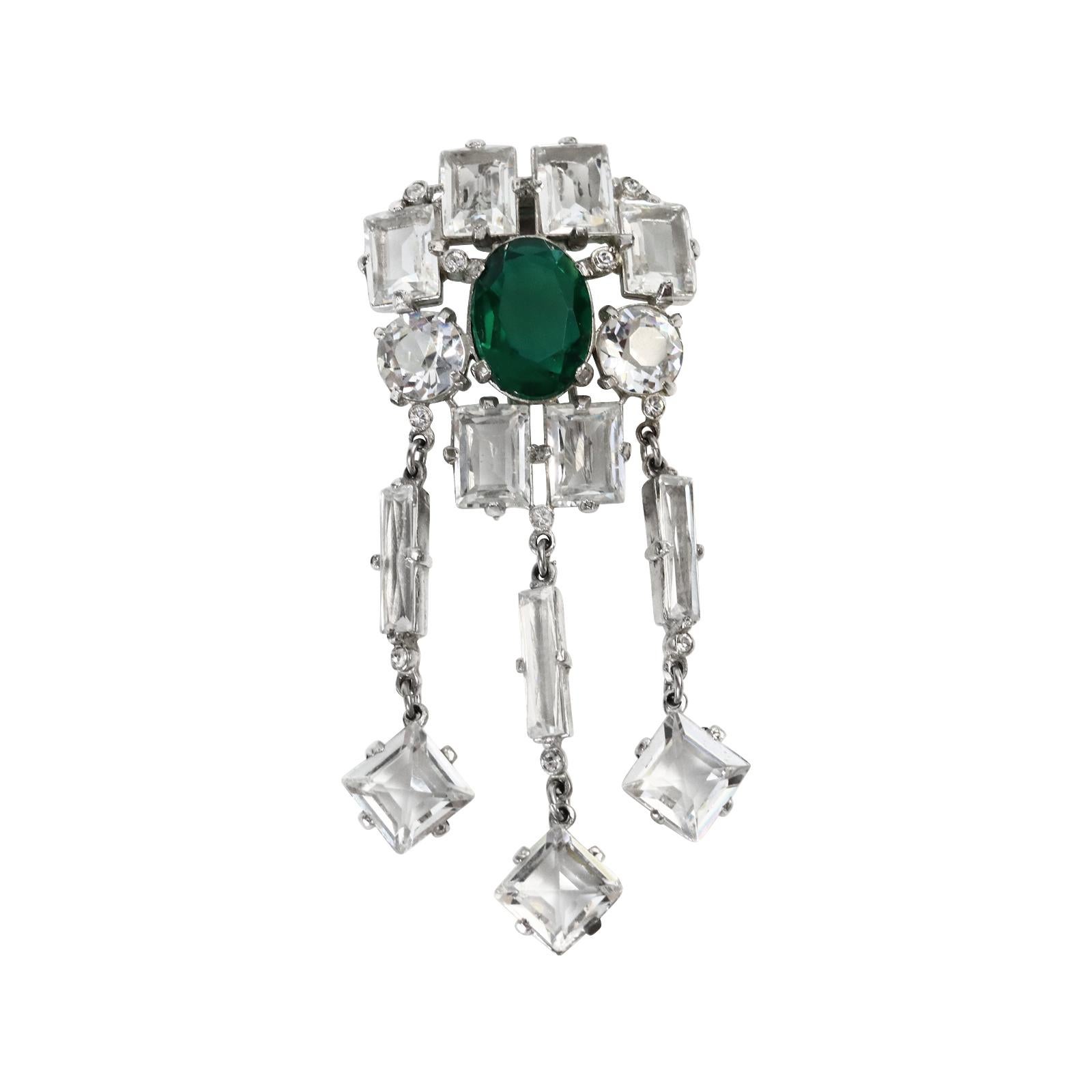 Vintage Open Back Dangling Crystal Clip Circa 1940s. This gorgeous piece has clear open back crystals that surround a large oval Emerald Crystal in the middle. There are various size and cuts in the brooch which add such depth to this piece. Looks