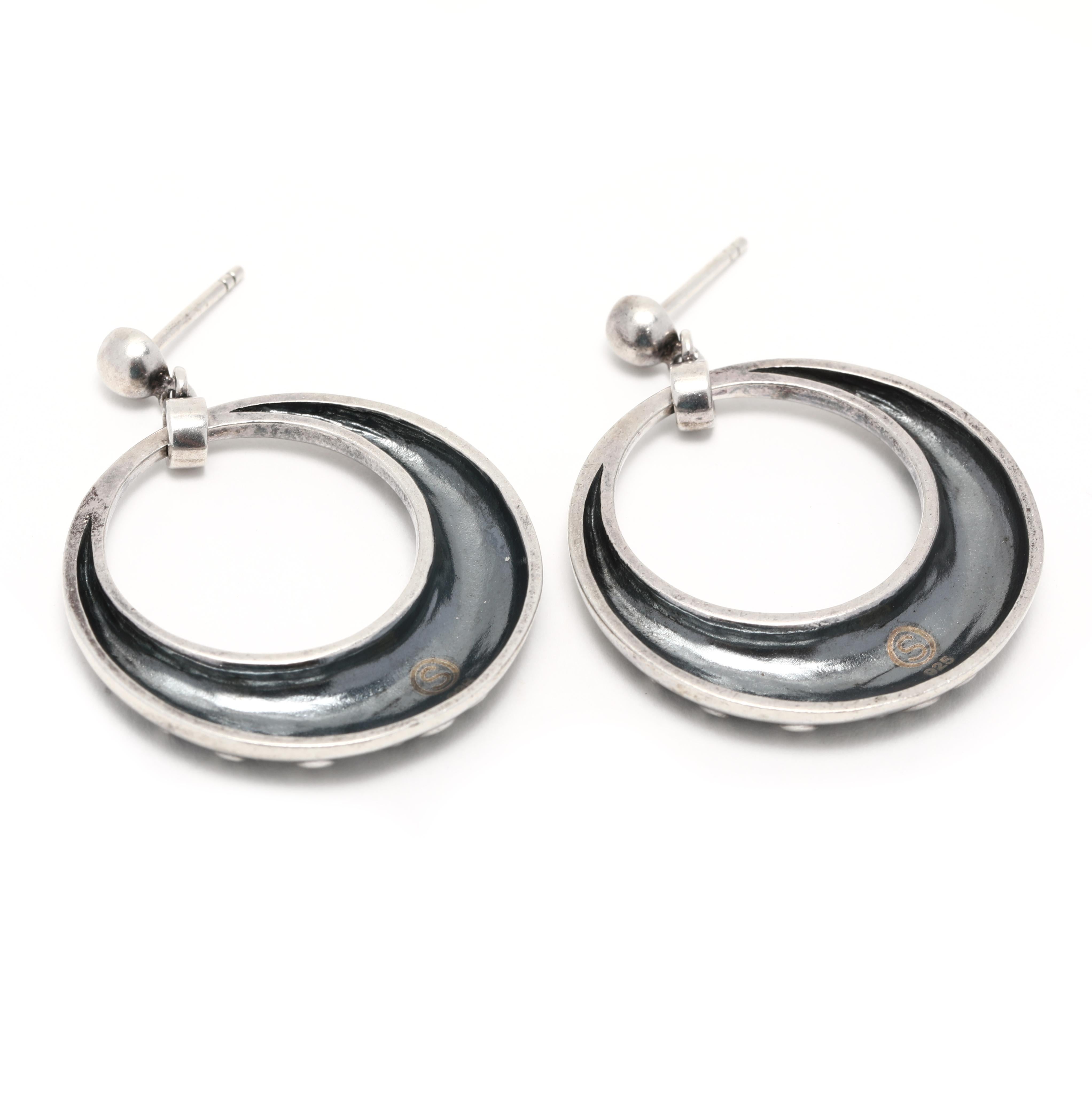 These stunning vintage open circle scroll detail dangle earrings are crafted from sterling silver and measure 1 3/8 inches in length. These unique silver earrings feature a delicate open circle detail that is perfect for any occasion. Their dangle