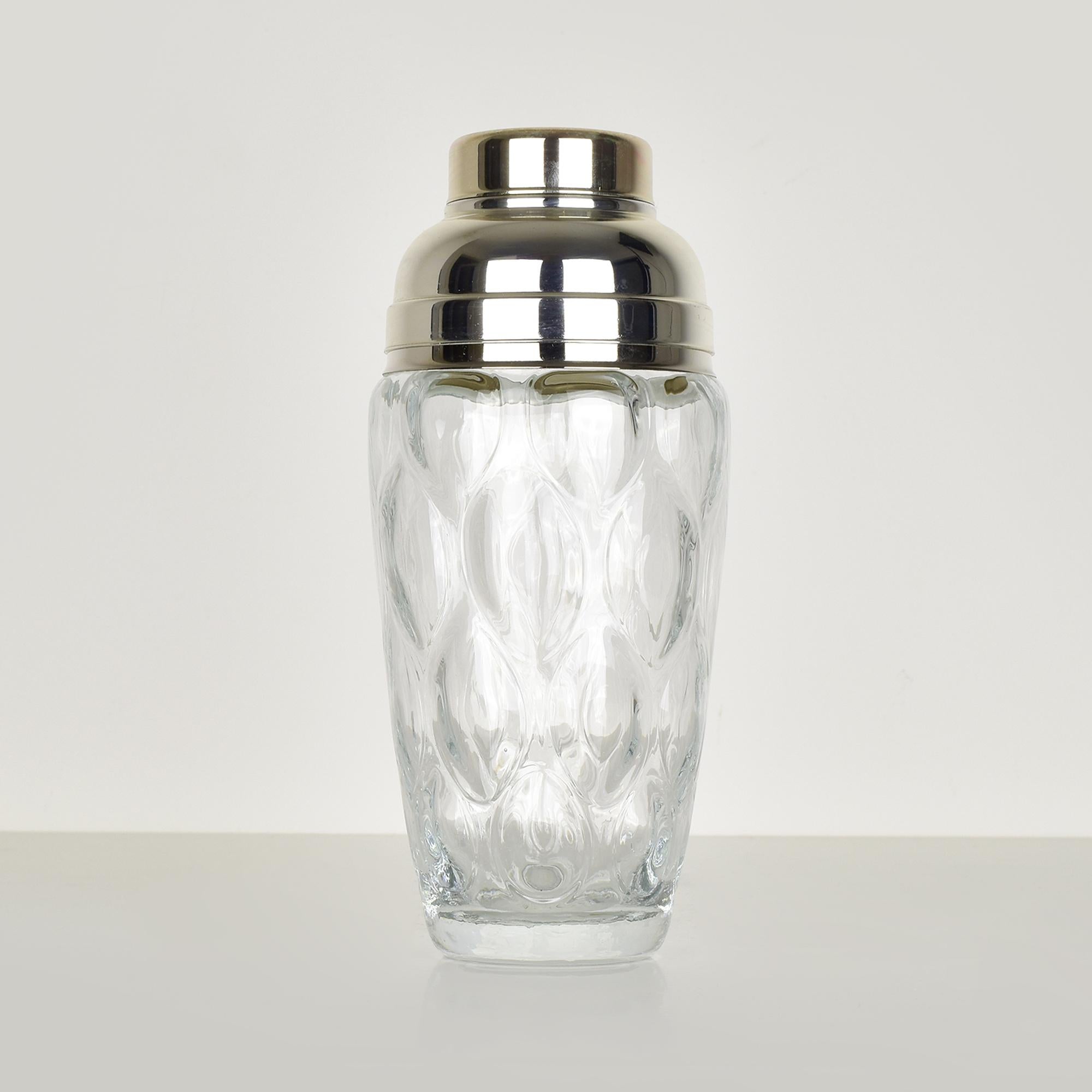 This exquisite vintage cocktail shaker combines the elegance of optical glass with the refined touch of silver plating, perfect for stylish home bars or collector’s display. The glass features an intricate, raised leaf pattern that adds both texture