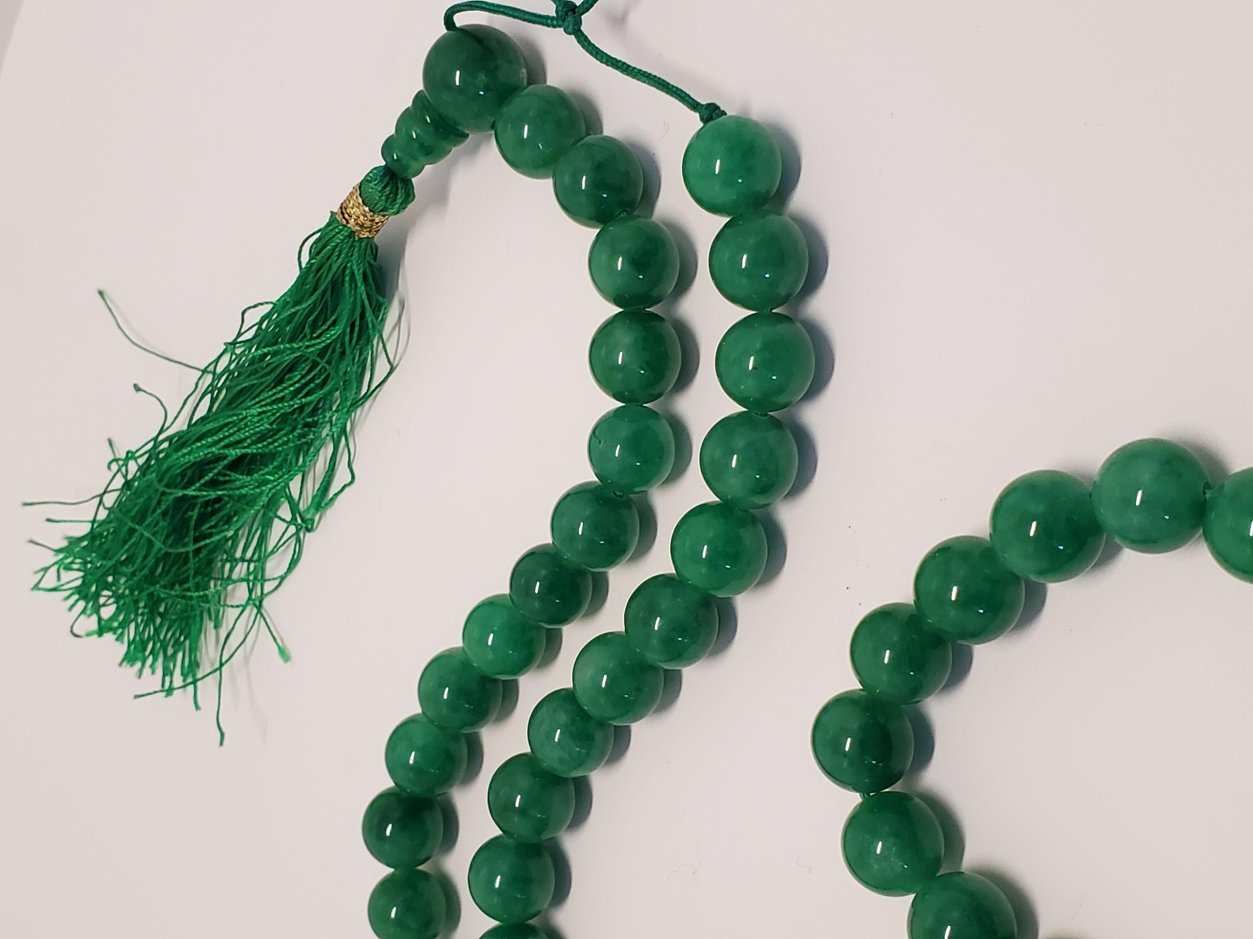 This vintage or antique necklace of emerald green jadeite beads, also known as mala or prayer beads, are a delight to handle. This necklace consists of a strand of 67 round jadeite beads, each 10 mm in diameter and uniform in shape and size. The