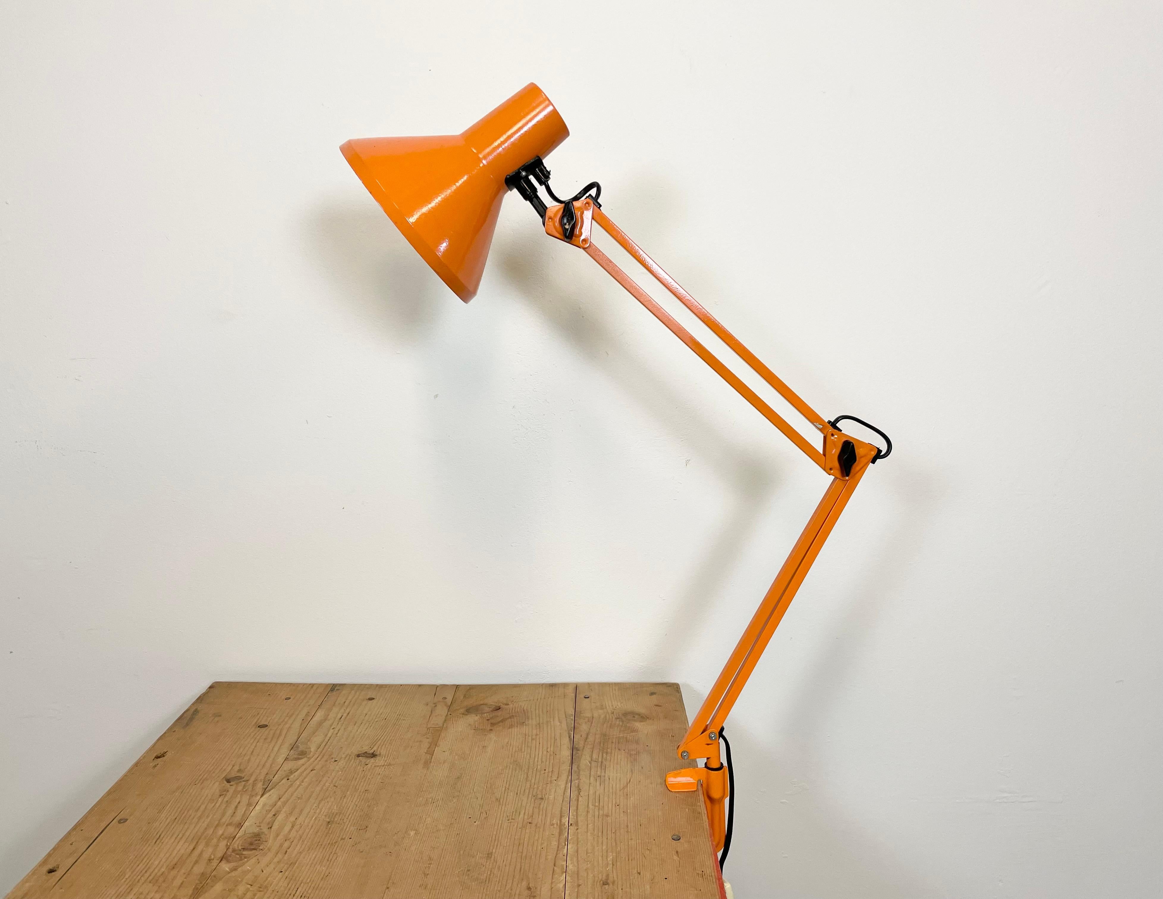Vintage orange adjustable table lamp made in former Czechoslovakia during the 1970. It features an aluminium shade and an iron arm and clamp base.The socket requires standard E 27/ E 26 light bulbs. Original vintage condition.