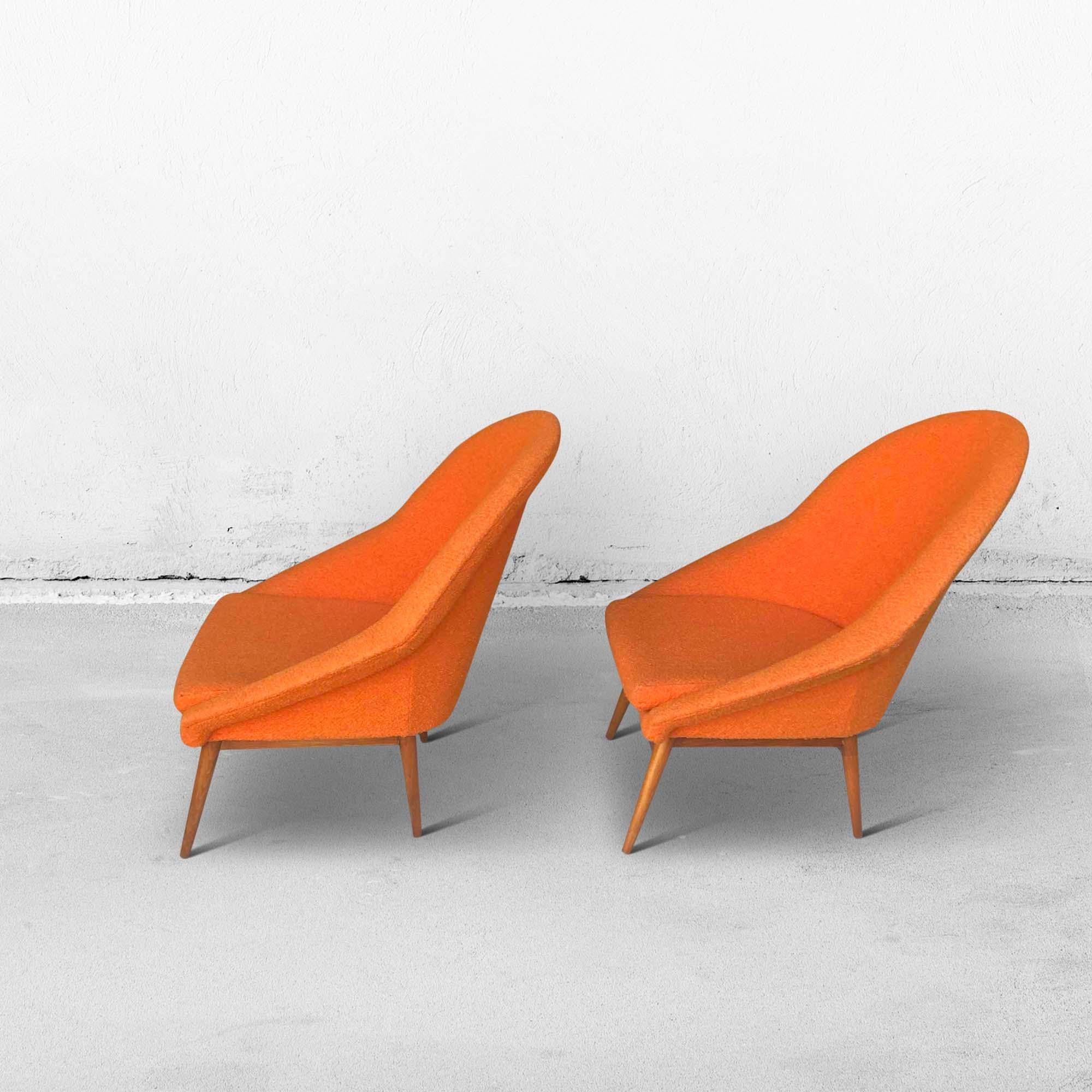 Un ensemble de sièges baquets d'une couleur orange foncé. Ces fauteuils datent des années 1960. Le tissu ne présente aucune tache ou dommage et le confort d'assise est encore très bon. Les pieds en bois sont encore très solides et ont été