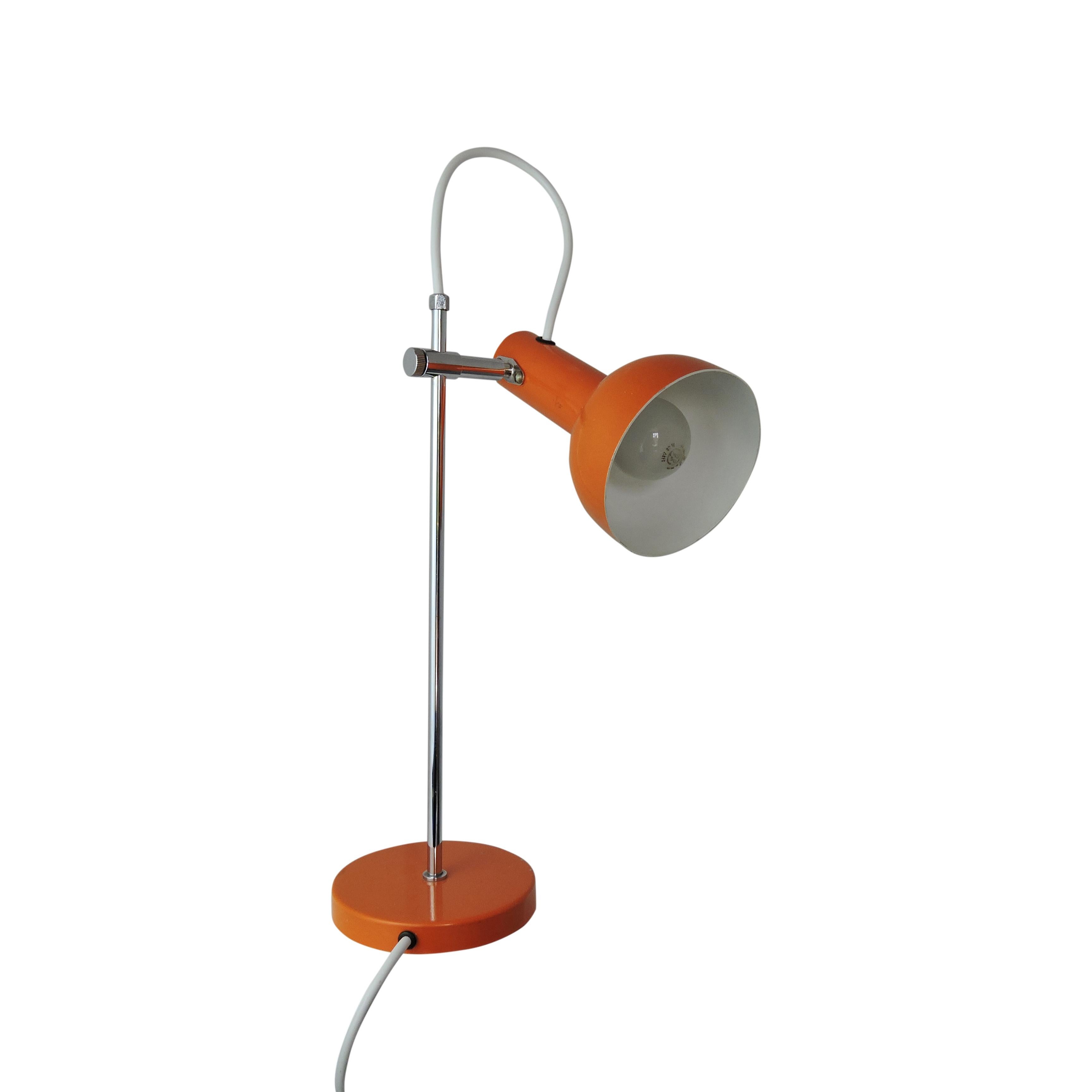 This orange desk lamp features an adjustable lampshade.