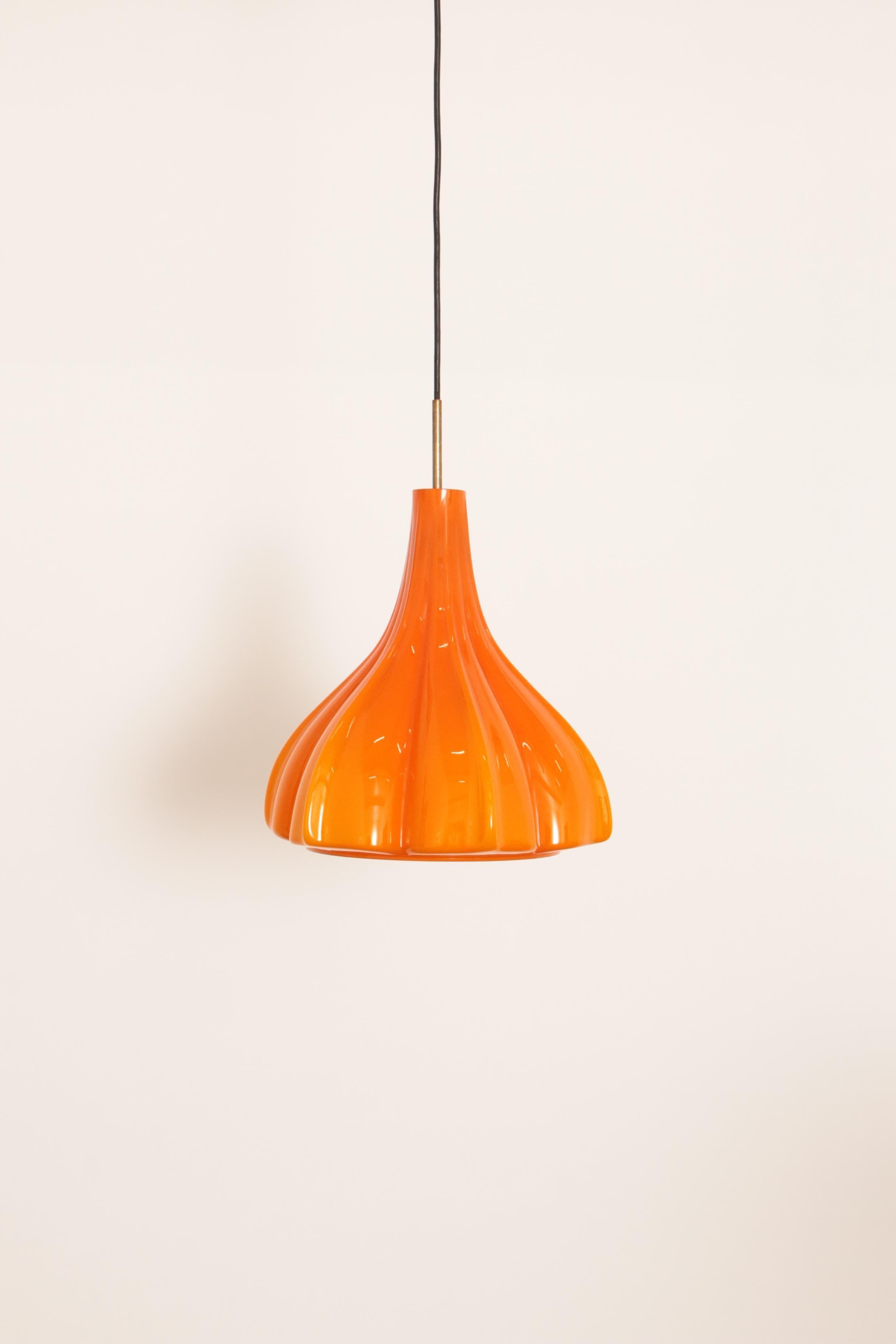 Particularly rare shaped orange glass hanging lamp by Peill and Putzler, produced around 1960 in Germany. Has a beautiful bright orange color and gives a very warm light.

Typical design of the German makers. More glass pendant lights in