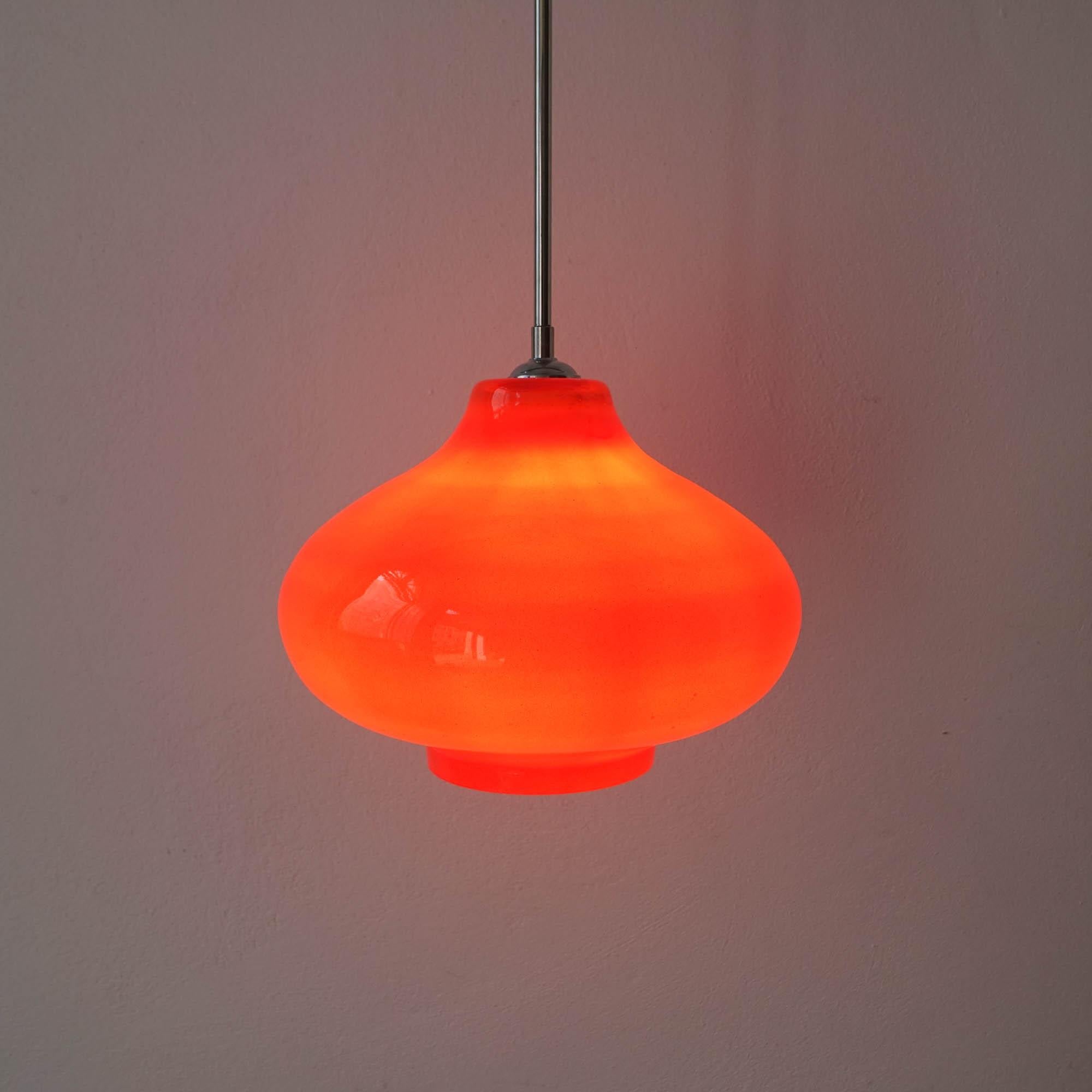Cette lampe suspendue a été conçue et produite par Marinha Grande, au Portugal, dans les années 1960. Il est réalisé dans un verre opalin orange avec toutes les parties métalliques chromées d'origine. En état original et bon.