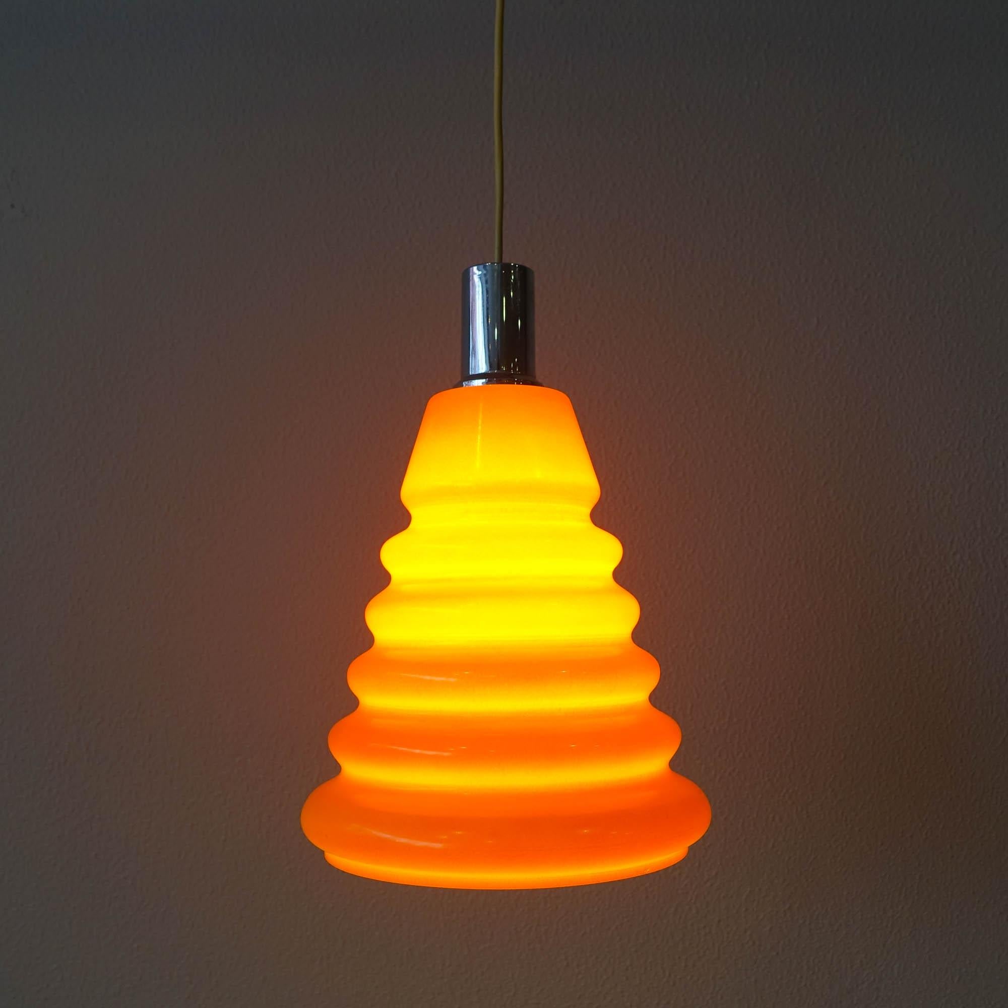 This pendant lamp was design and produced by Marinha Grande, in Portugal, during the 1960's. It is made in an orange opaline glass with all the original chrome metal parts. In original and good condition.