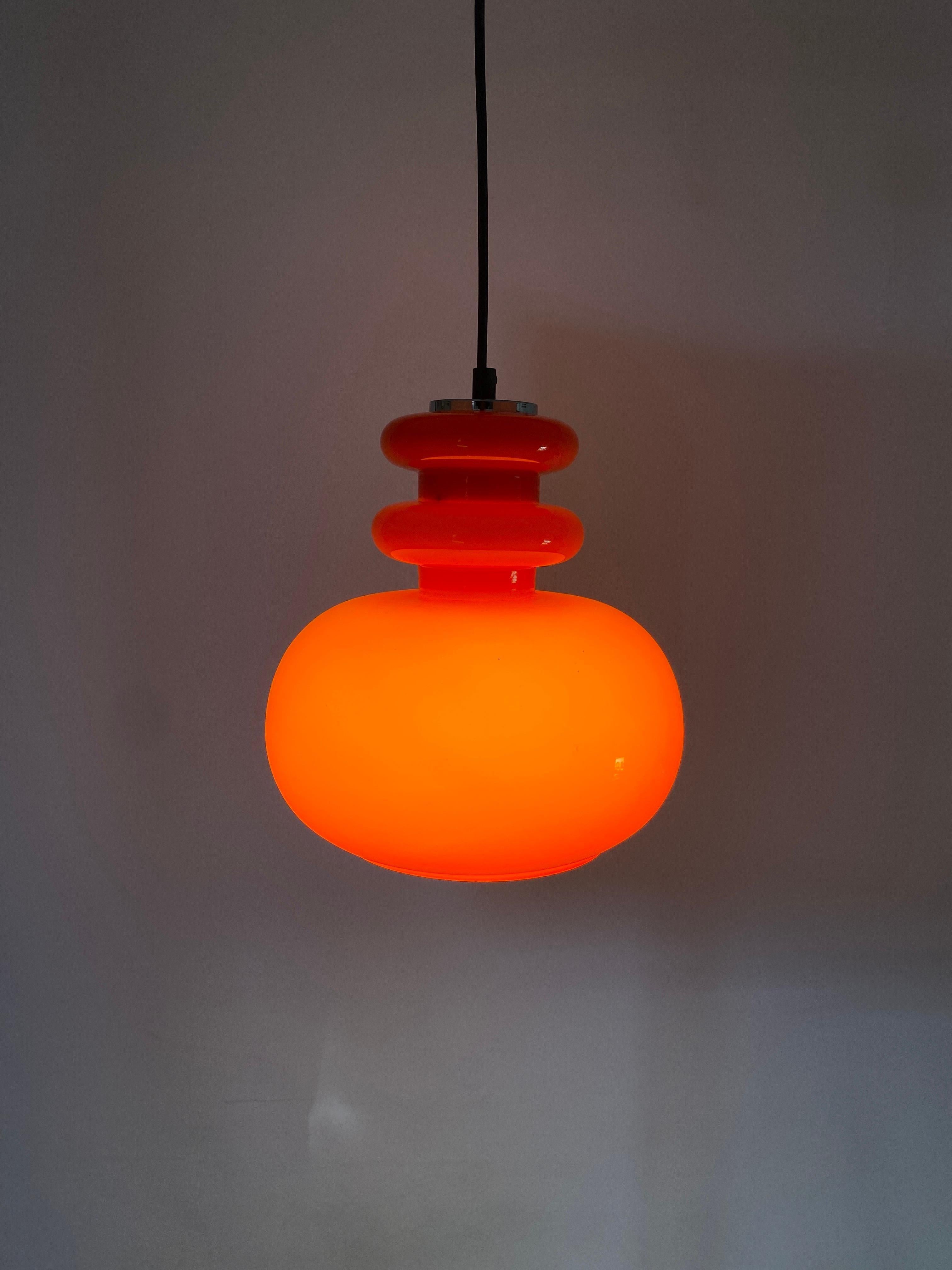 Beautiful German design by Peill and Putzler, produced around 1960. Has a nice light red color and gives a very warm light. 

Typical design of the German makers, also resembles the Swedish designs. More colored  glass pendant lights in