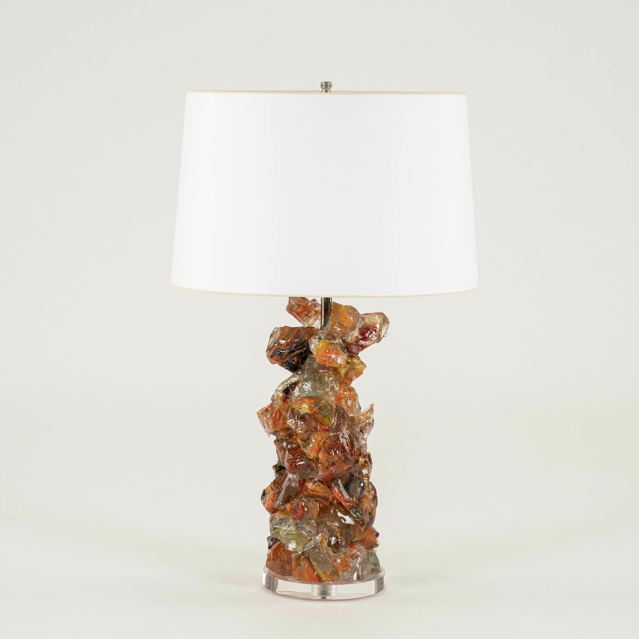 Illuminate your space with this cheeky chic vintage table lamp featuring a uniquely textured mix of orange, amber and clear rock glass supported with lucite base, and vintage paper shade.
