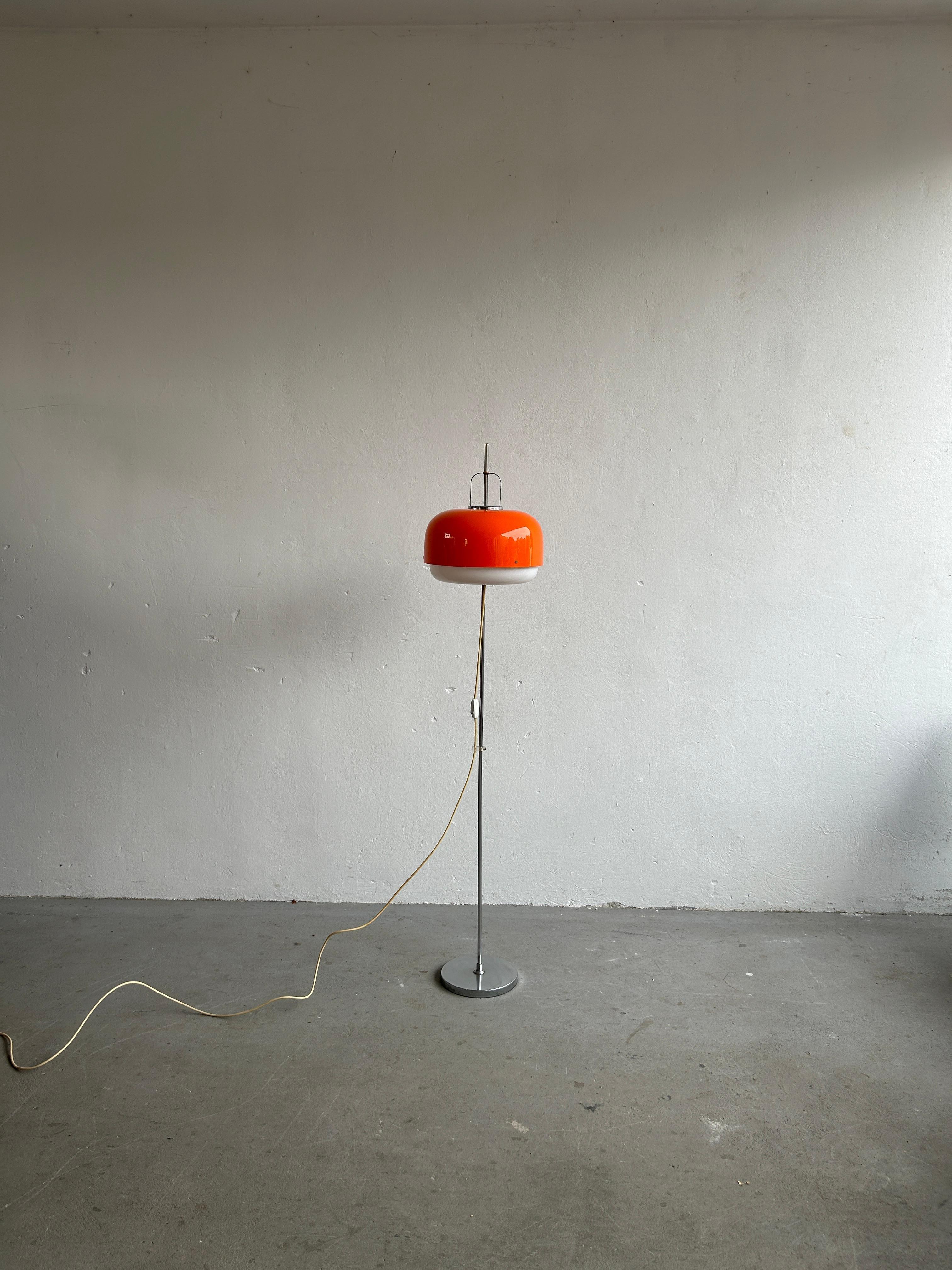 A beautiful orange and white mid century floor lamp designed by Harvey Guzzini Studio for Meblo in the 1970s. Made from chromed metal and plastic. Can be adjusted to any height.

The item is in excellent original vintage condition and fully