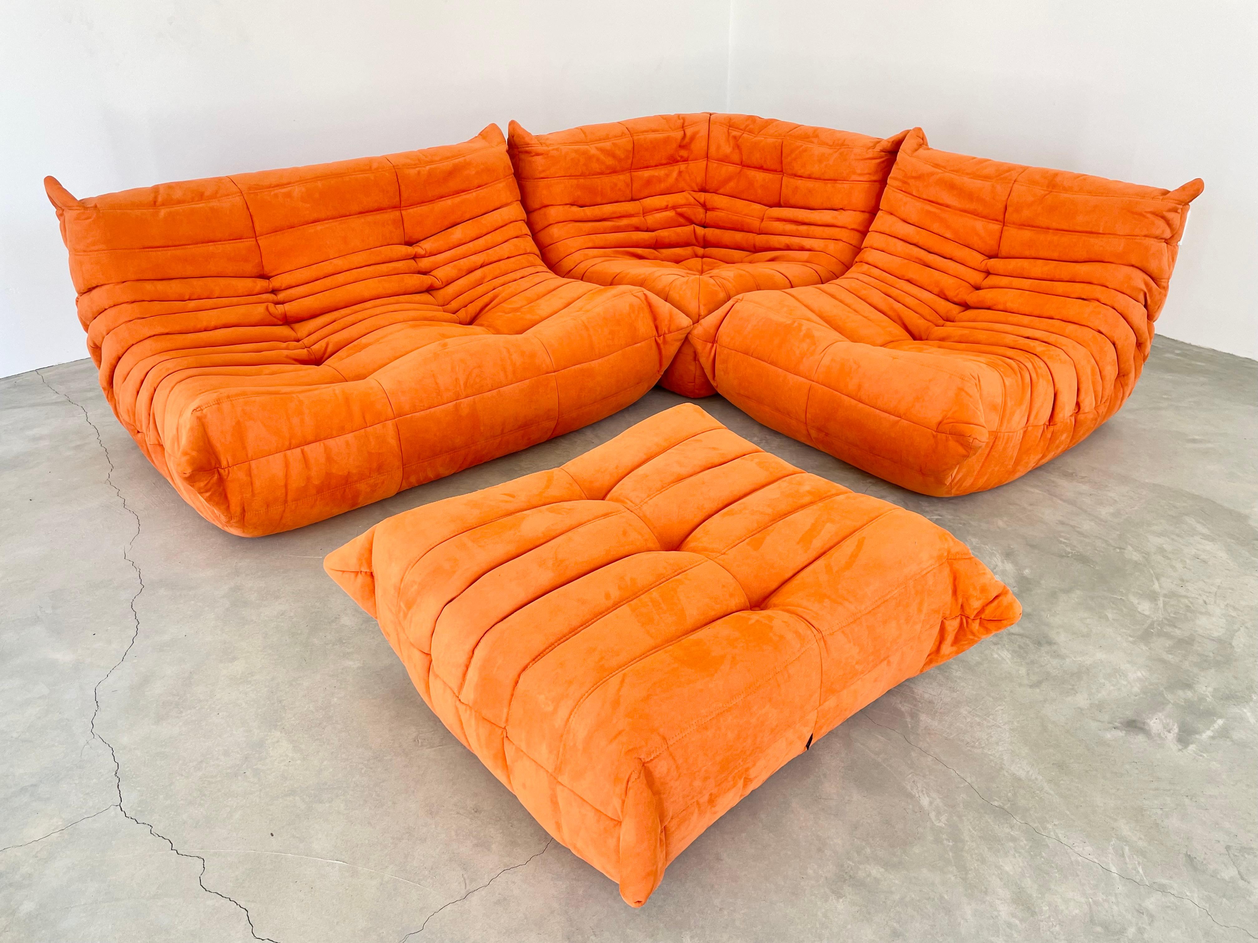 Classic French Togo set by Michel Ducaroy for luxury brand Ligne Roset. Originally designed in the 1970s the iconic togo sofa is now a design classic. This set comes in its original orange microsuede.

Timeless comfort and style make this four