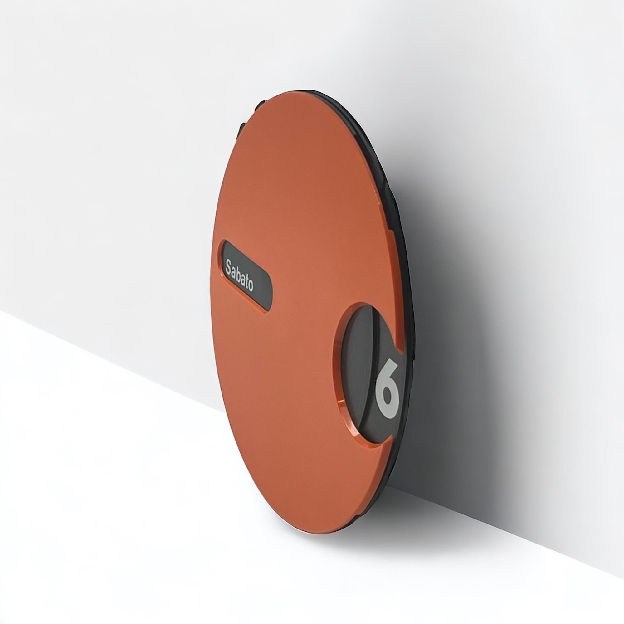Journey back to the space age era with this rare Italian wall calendar, a true testament to retro-futuristic design. Crafted in the 1970s, this space age calendar features a distinctive circular orange body adorned with a rotating black dial,