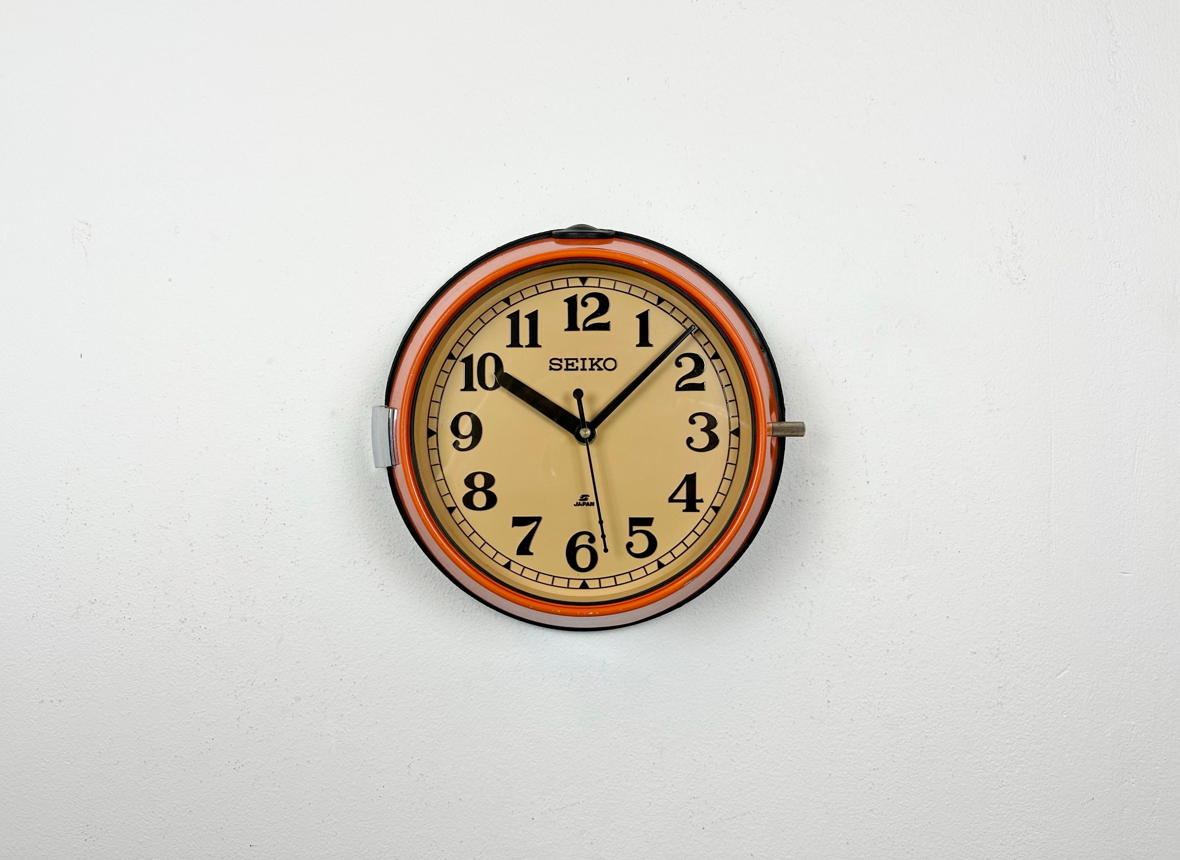 Vintage Seiko navy slave clock designed during the 1970s and produced till 1990s. These clocks were used on large Japanese tankers and cargo ships. It features an orange metal frame, a plastic dial and clear glass cover. This item has been converted