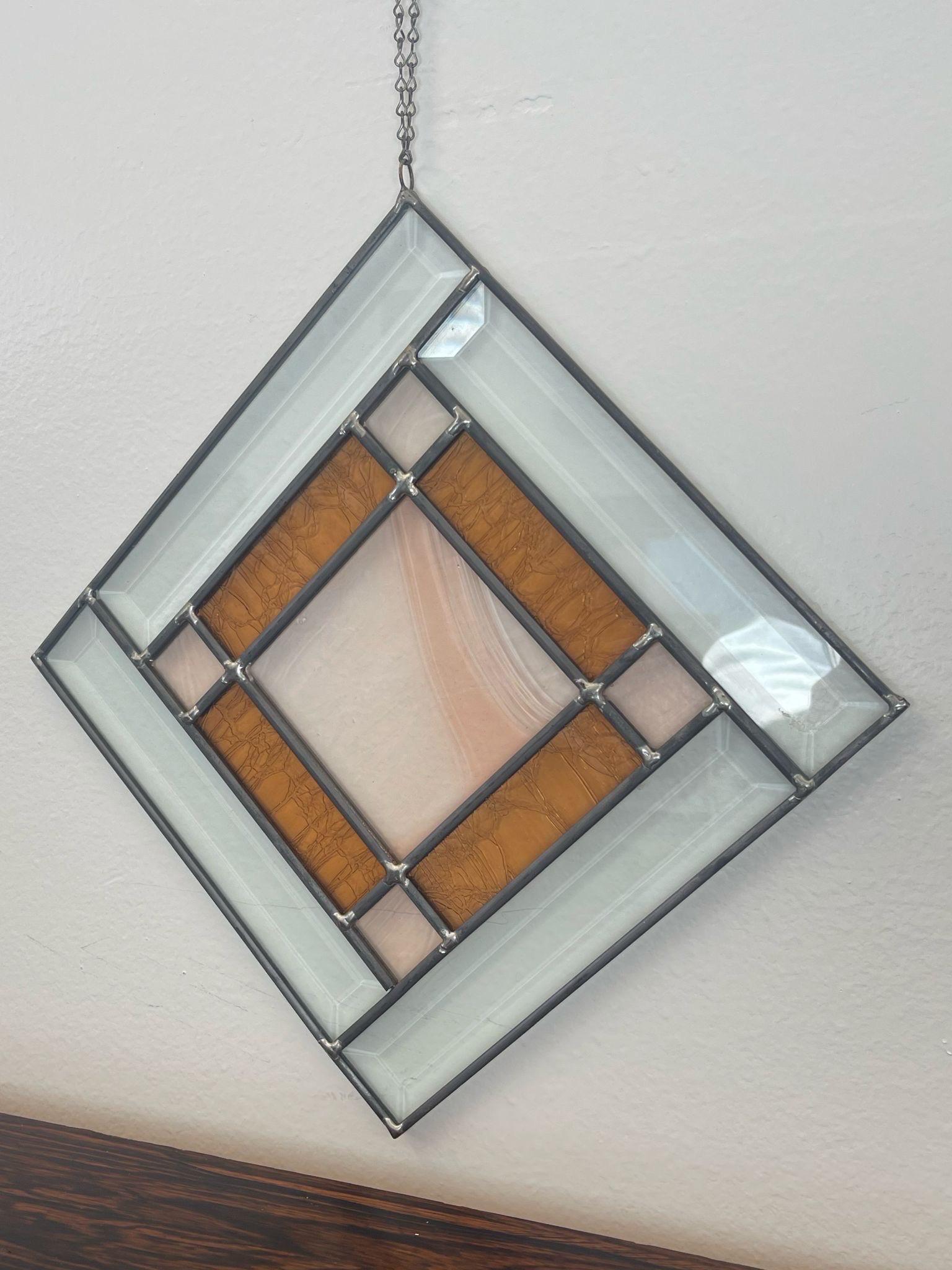 Square shaped stain glass Art with orange toned Accents. Beveled clear glass as the border. Vintage Condition Consistent with Age as Pictured.

Dimensions. 10 W ; 1/4 D ; 10 H