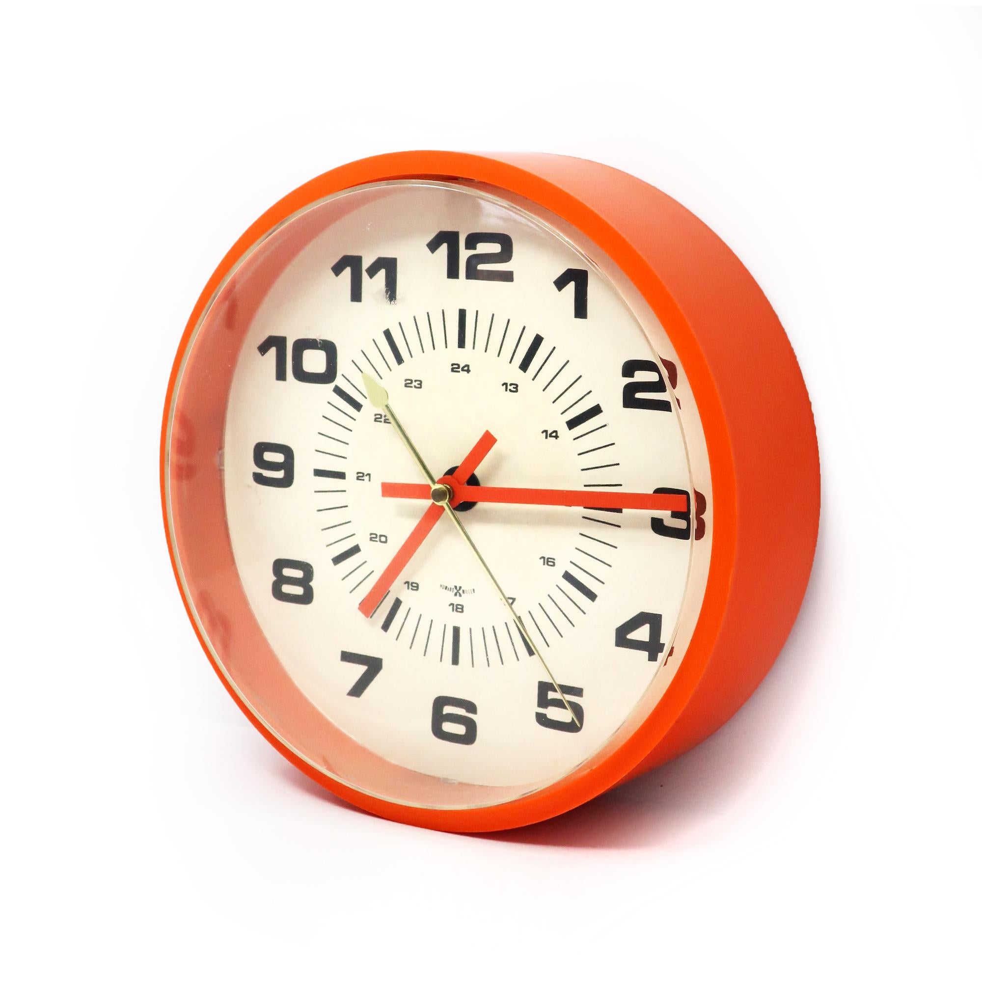 A perfectly Mid-Century Modern wall clock by Howard Miller with an orange plastic case, white face with black numbers, and orange and brass hands.

In good vintage condition with light scratching to cover (see photos). Plugs in and runs