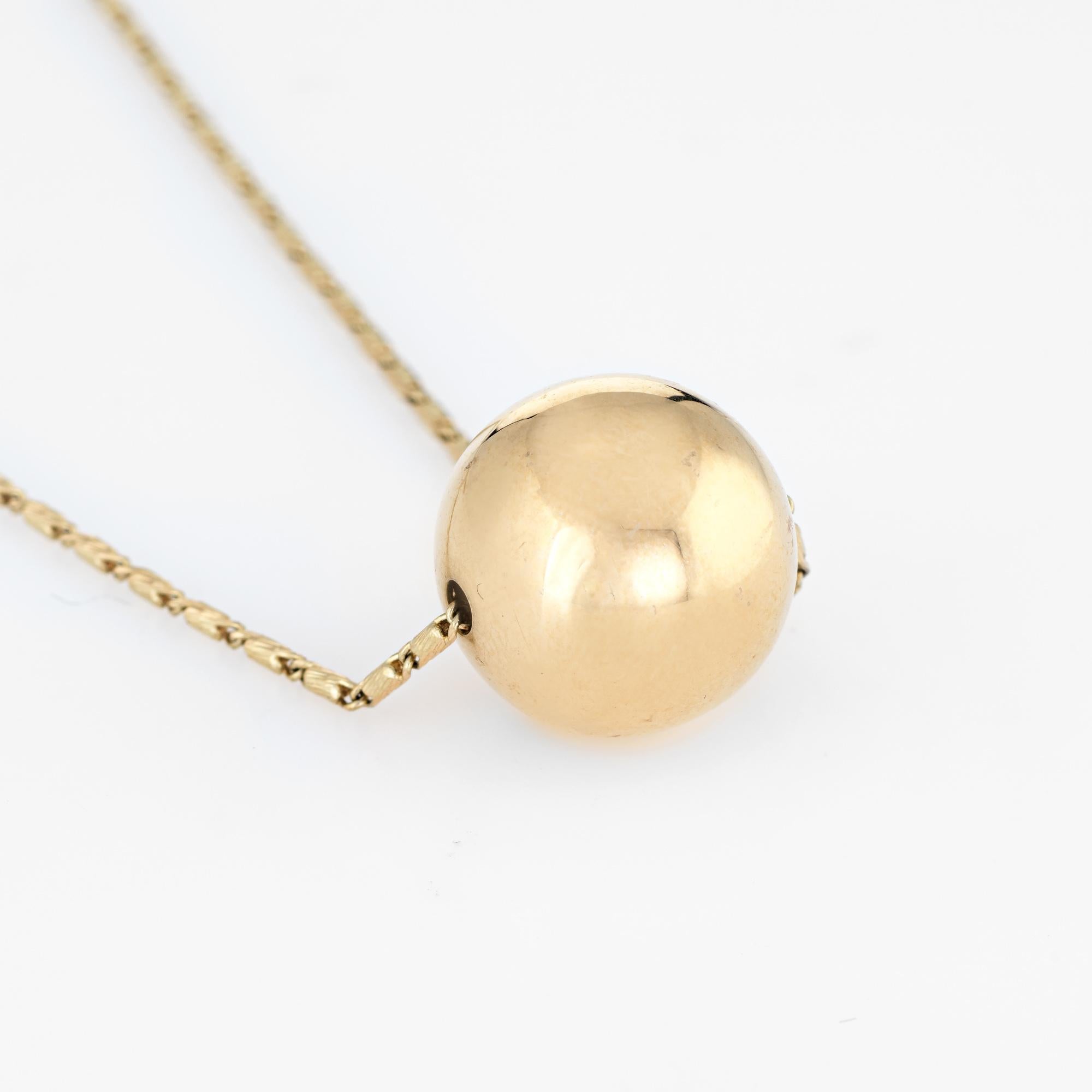Elegant and finely detailed vintage orb necklace (circa 1970s to 1980s), crafted in 14 karat yellow gold.  

The necklace measures 17 inches in length and sits nicely below the nape of the necklace. The orb measures 14mm (0.55 inches). The necklace