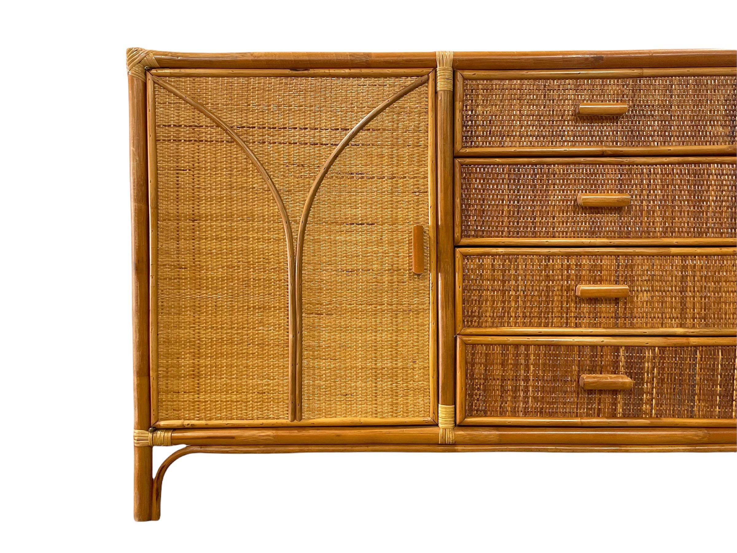Stunning organic modern mid century buffet credenza, circa 1970s. Rattan and Mahogany case with raffia veneer and bamboo detail on the door facades. Four center doors flanked on both sides by shelved cabinet space. Time capsule piece - this credenza