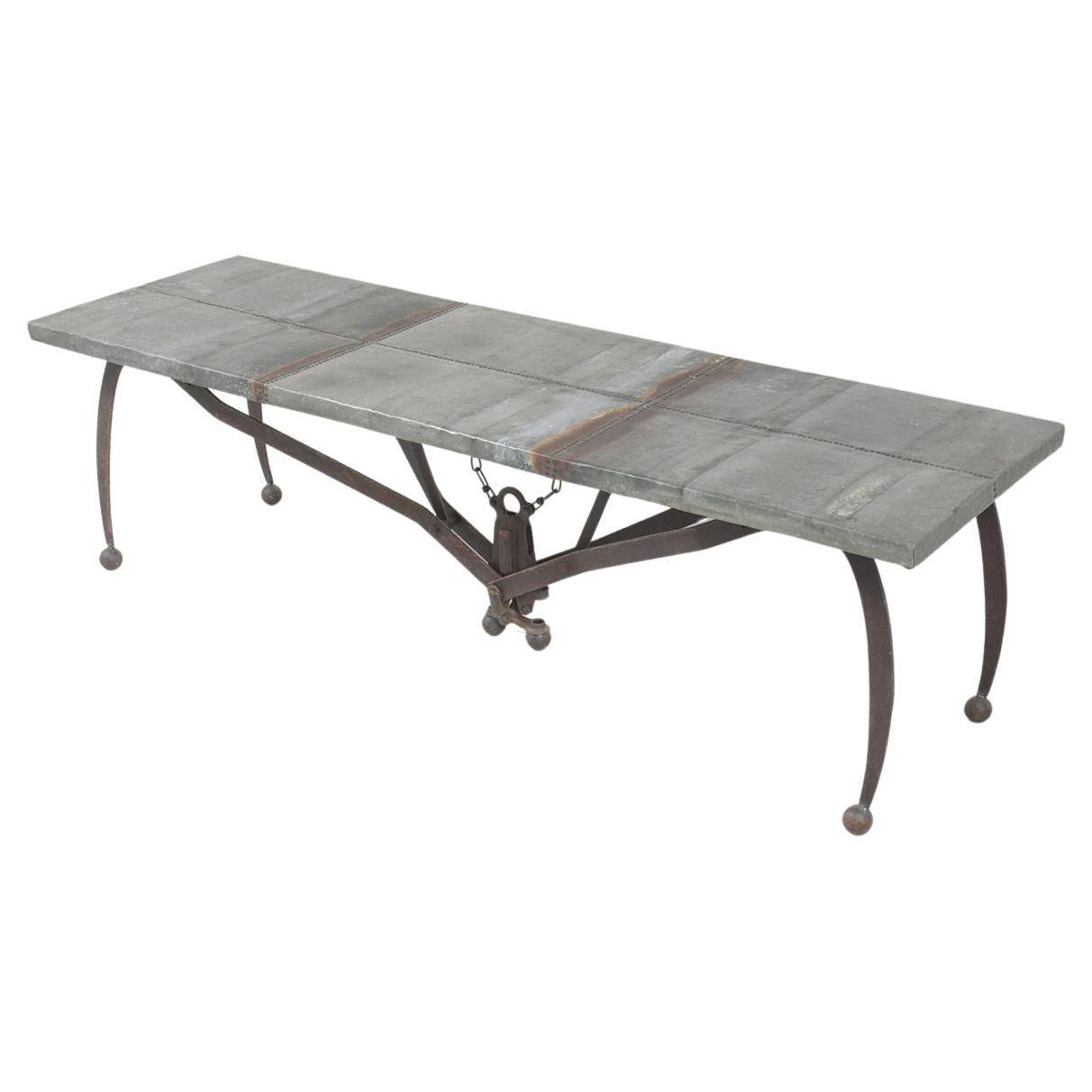 This vintage wrought iron coffee table is handcrafted out of wrought iron, reclaimed wood, and tin combination and has been newly restored by our professional team of expert craftsmen. The 1980s table top is made out of wood covered in a tin sheet