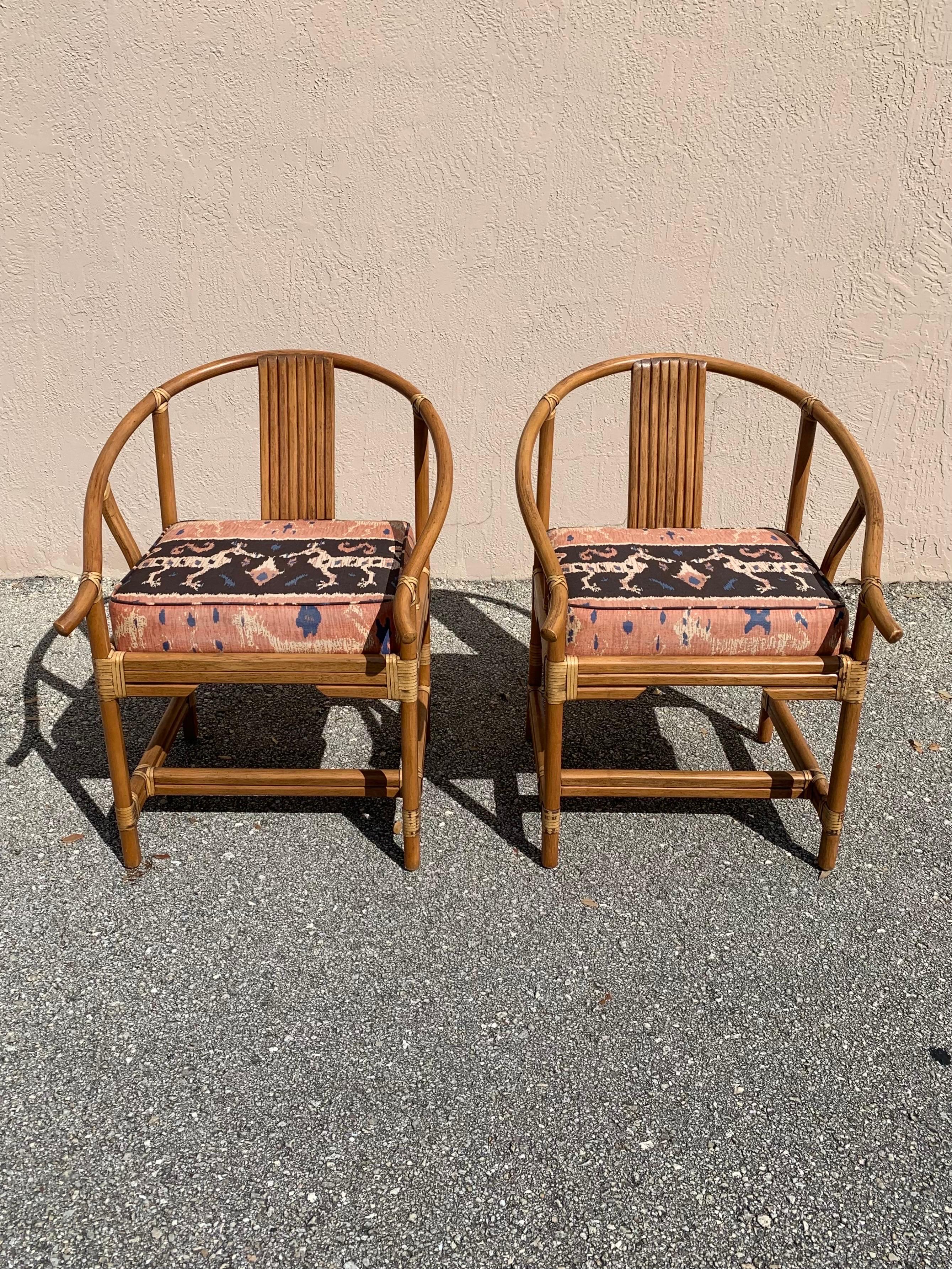 Beautiful pair of organic modern accent/lounge chairs by Ficks Reed. Carved wood affixed with leather strapping. Creating a beautiful mix of flowing and clean crisp lines. Unique fabric on a thick comfortable cushion. 

Mid 20th century design.